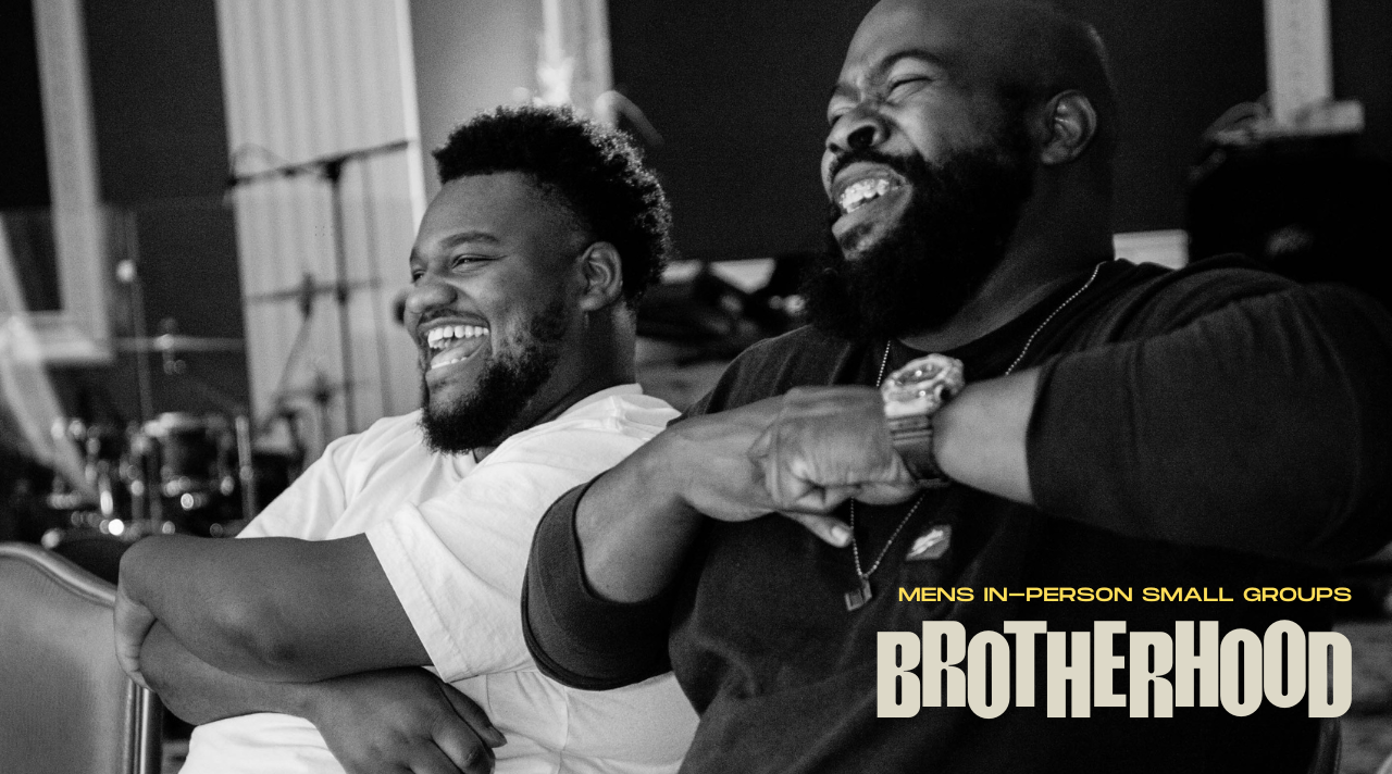 Two men laughing and smiling during Brotherhood, a small group in-person event for men.