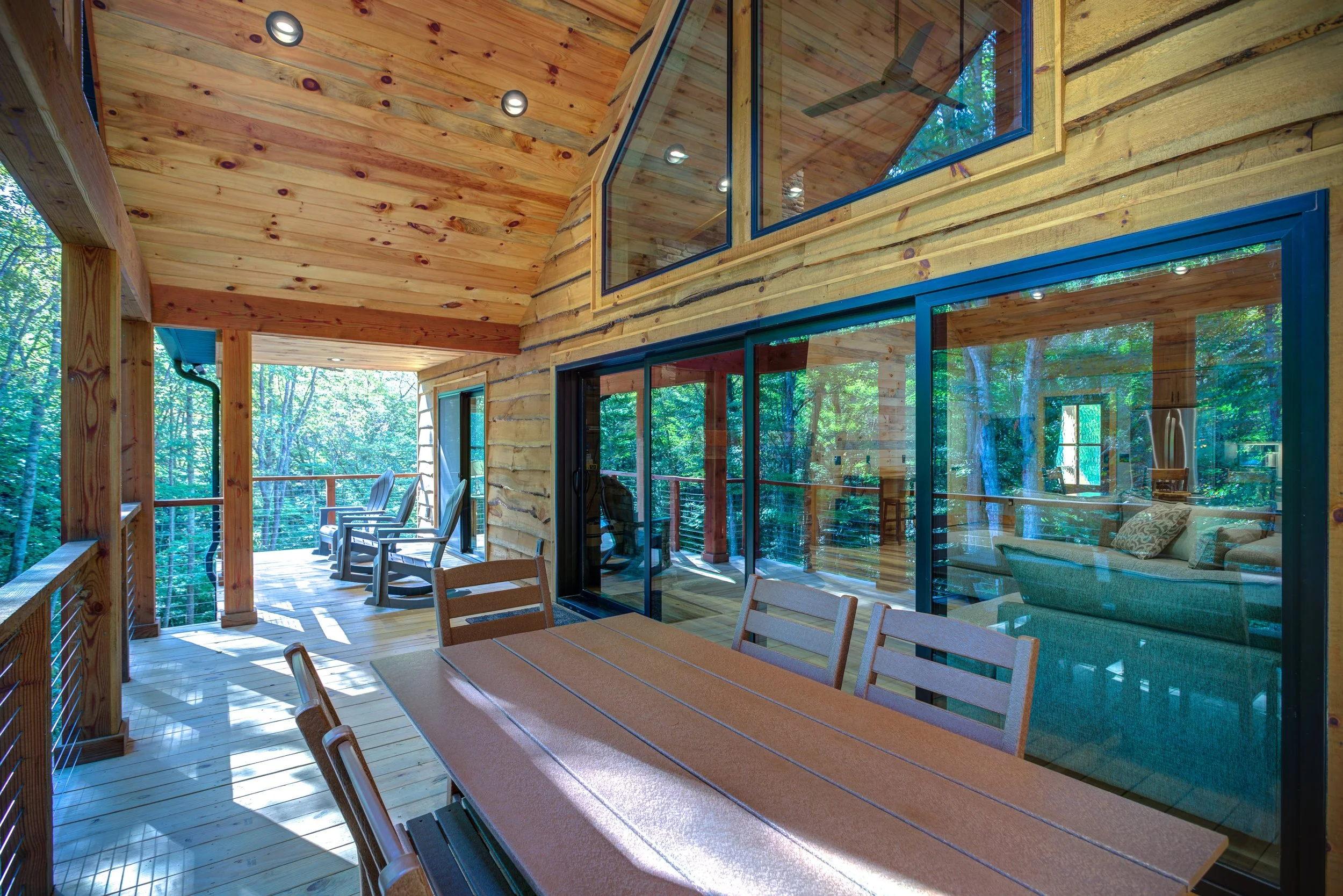 Oversized windows and expansive sliding glass doors fill the living room with natural light, showcase peaceful forest views, and create a seamless connection to the covered back porch. 🌲🏡
