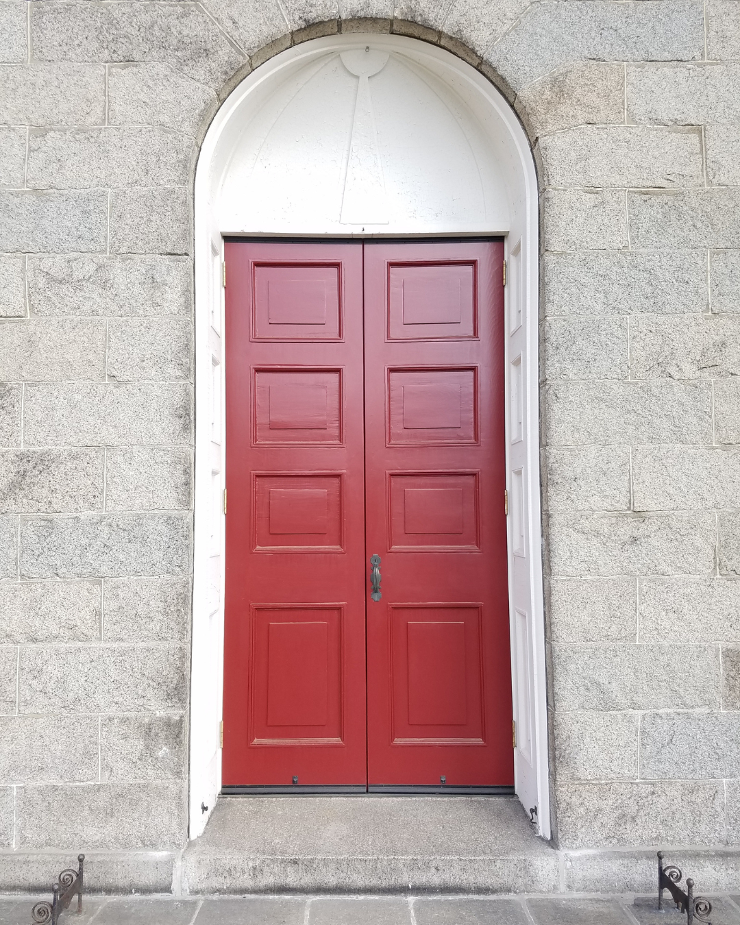 Red doors on an old stone church