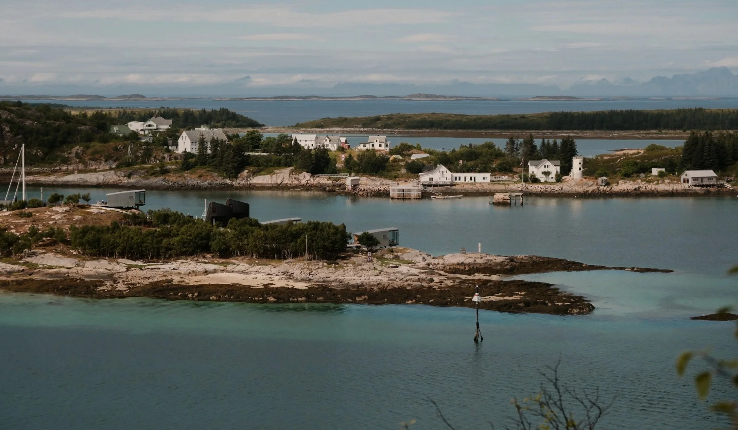 Sildrende landskap med øyer, hus og vann, typisk kystlandskap i Norge.