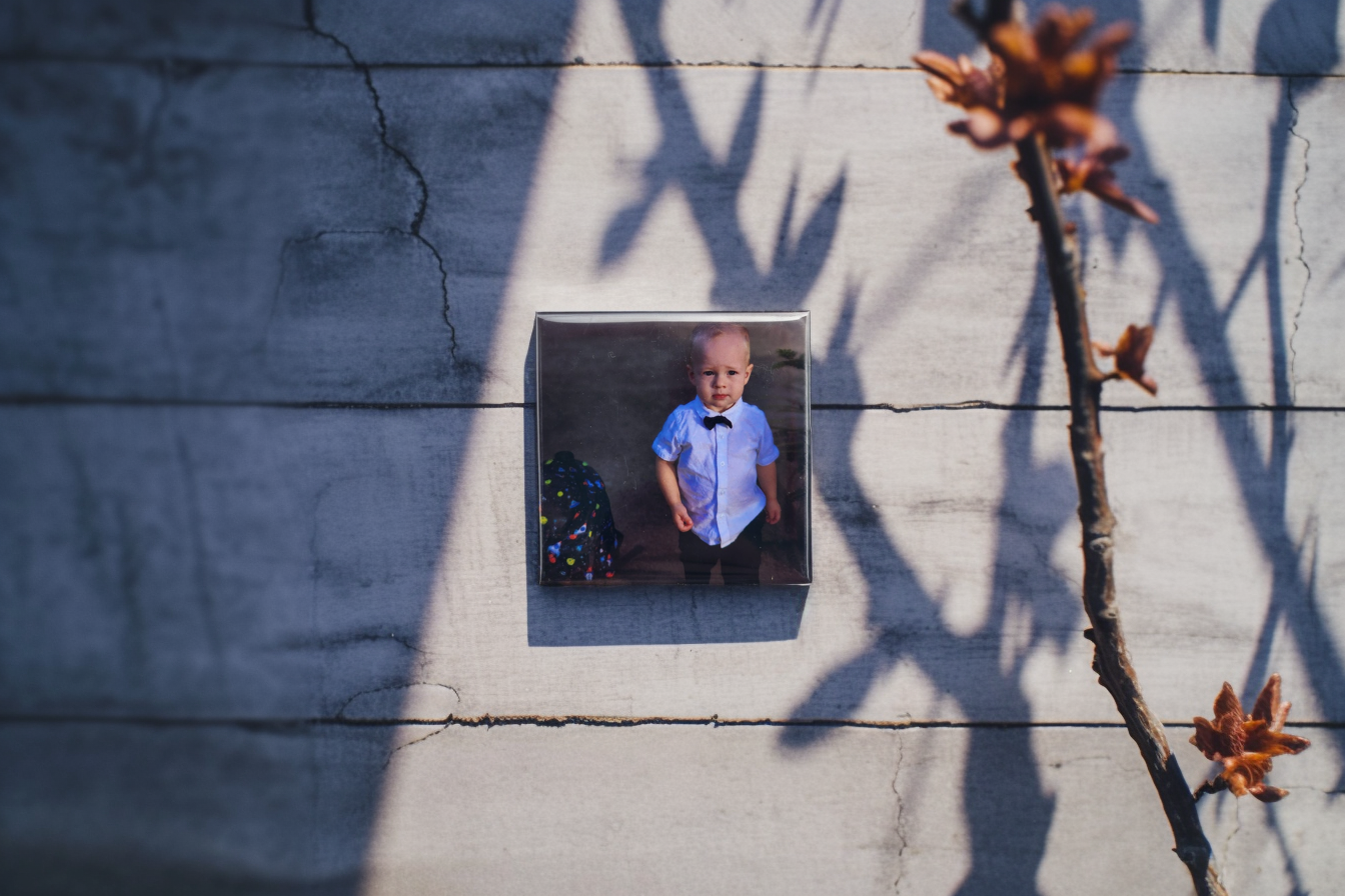Elegant photo magnet featuring a young boy in a white shirt and black bow tie, perfect for preserving timeless childhood memories in a modern display setting.