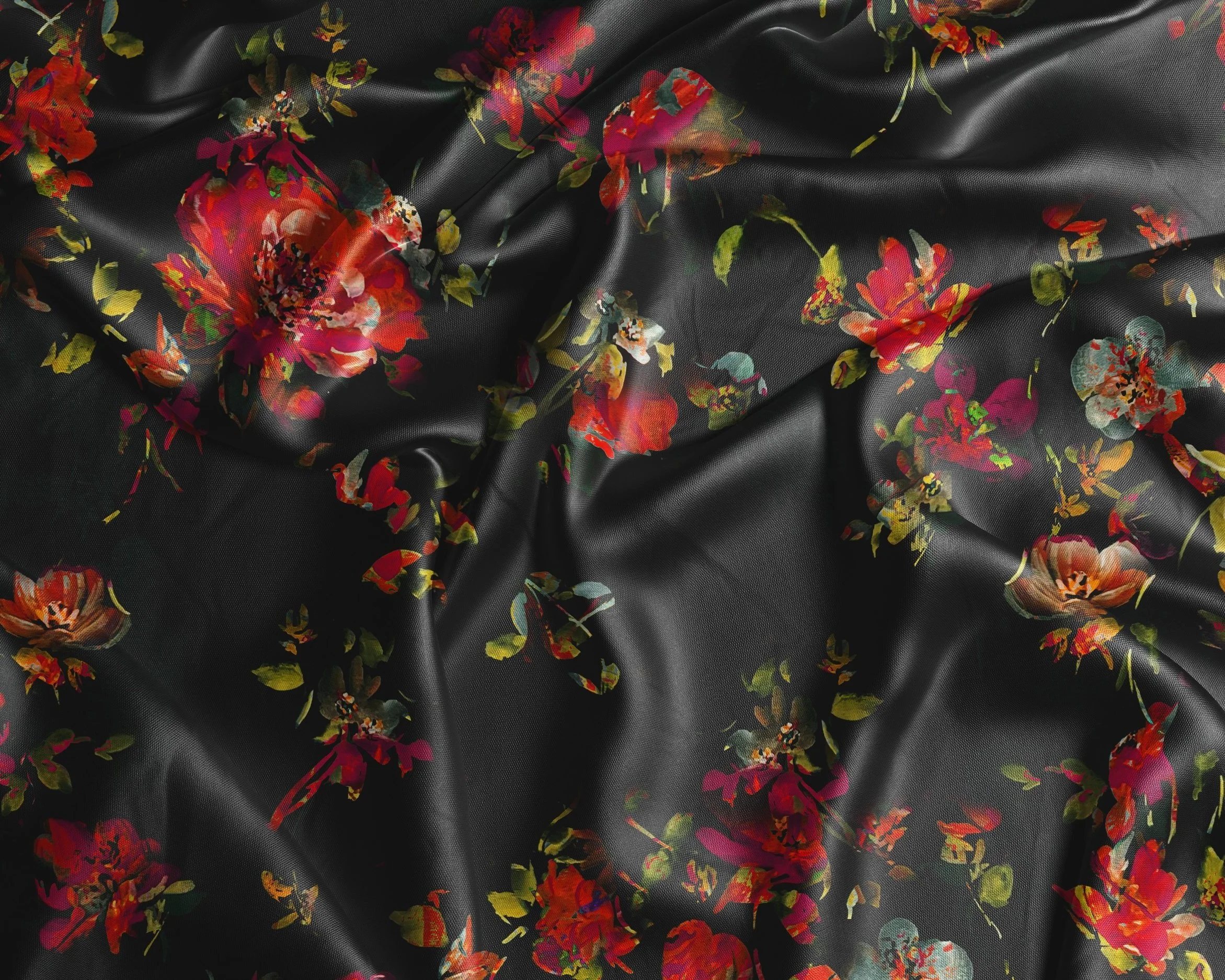 Black fabric with a vibrant red and green floral pattern, featuring large flowers and leaves.