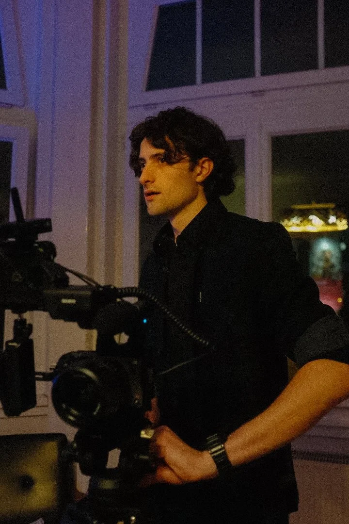 Man operating a professional video camera indoors.