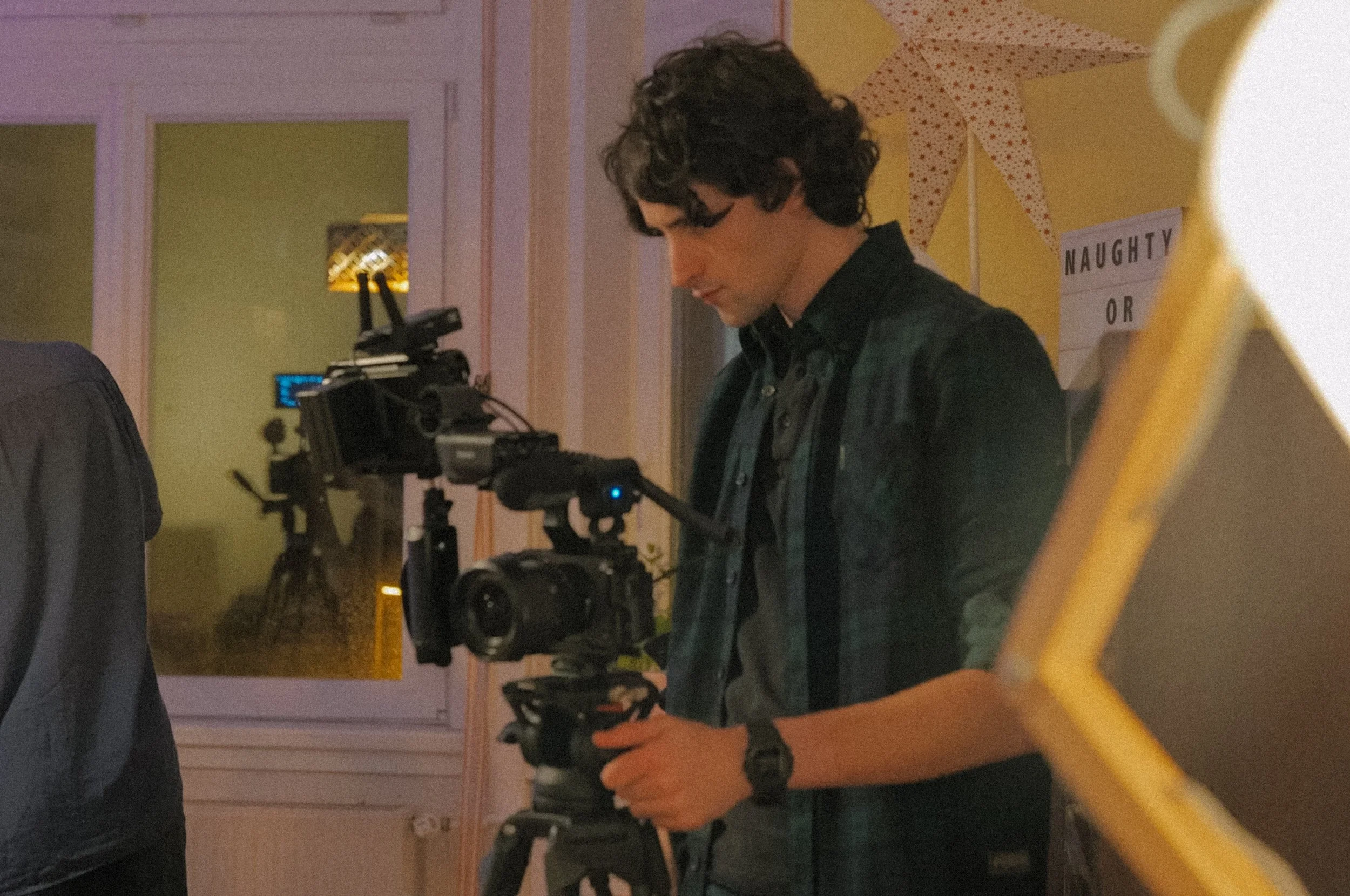 Person operating a professional camera setup indoors