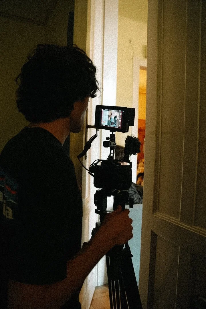 Person operating a professional camera on a tripod indoors