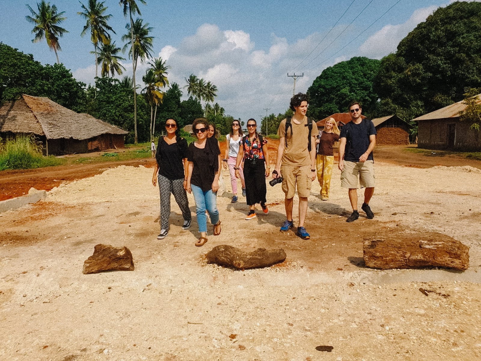 Group of people walking in a rural area with palm trees