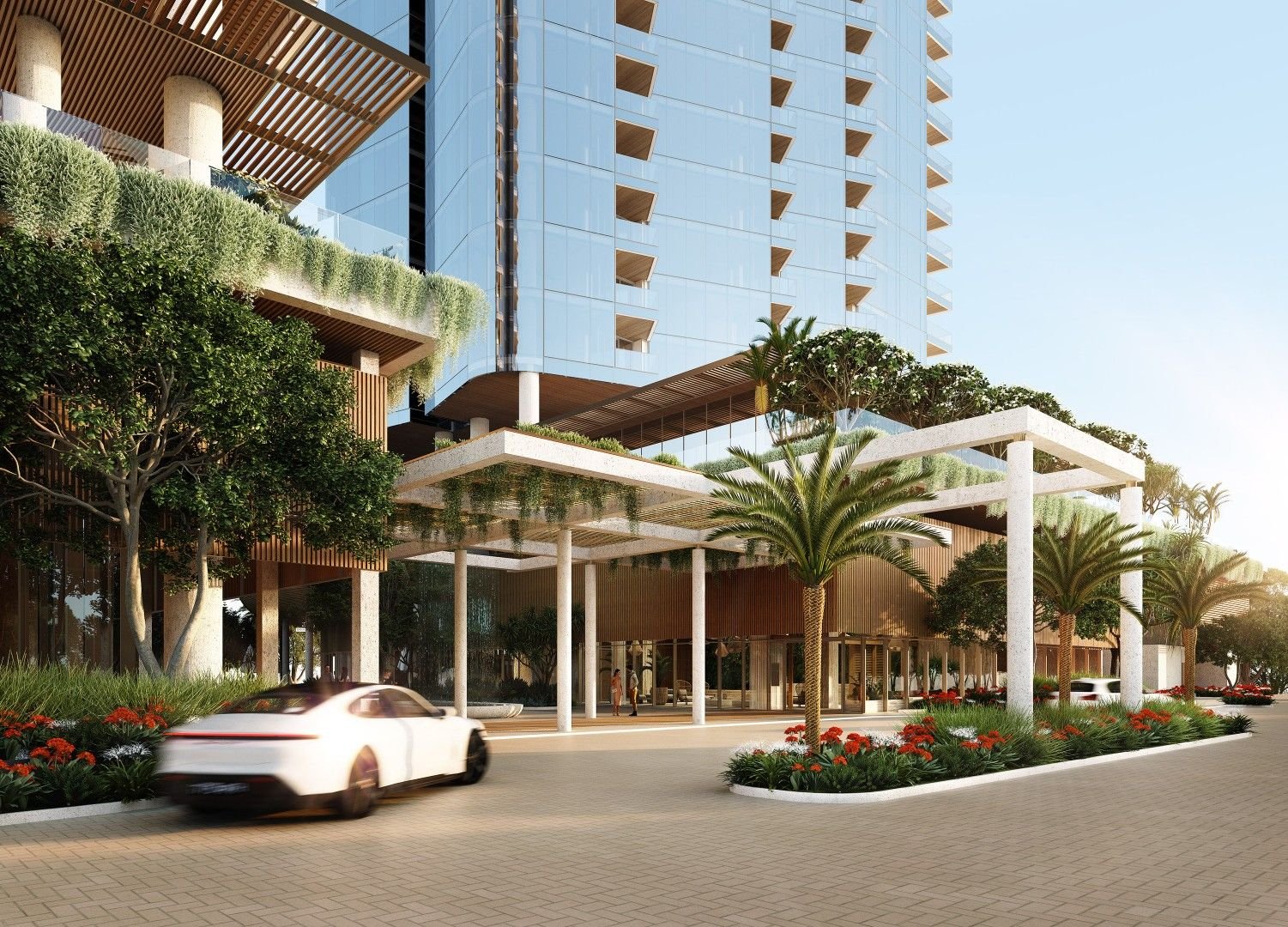 Modern building exterior with a white car in the foreground, greenery, palm trees, and a glass facade.
