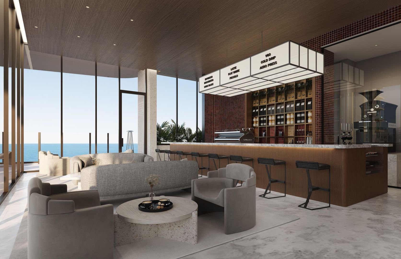 Modern ocean-view coffee shop interior with sofas, armchairs, a marble coffee table, and a counter with bar stools. Coffee menu signs hang above the counter displaying various drinks.