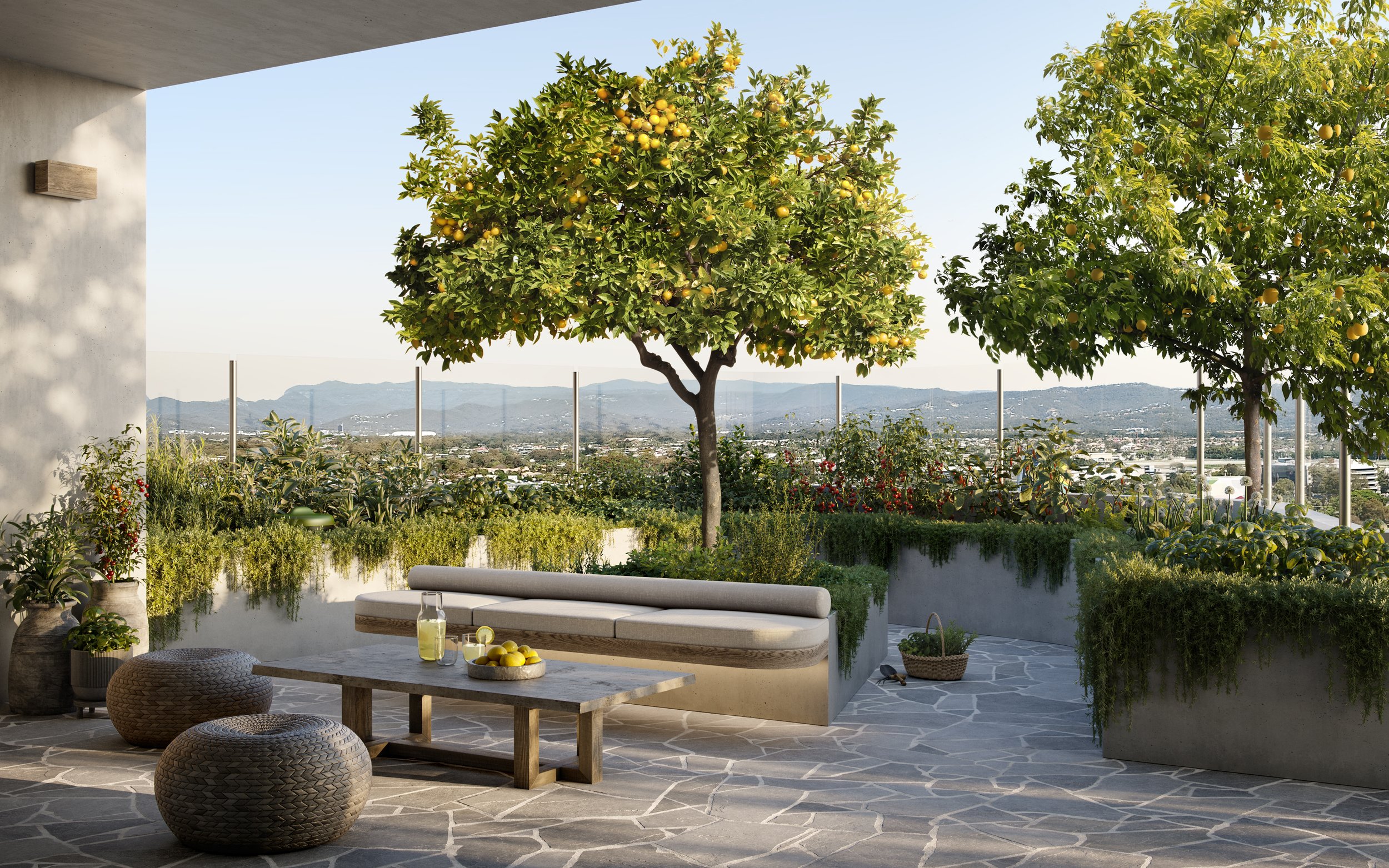 Rooftop garden patio with a stone floor, lemon trees, and mountains in the background. Features outdoor seating, a table with lemons and juice, potted plants, and lush greenery.