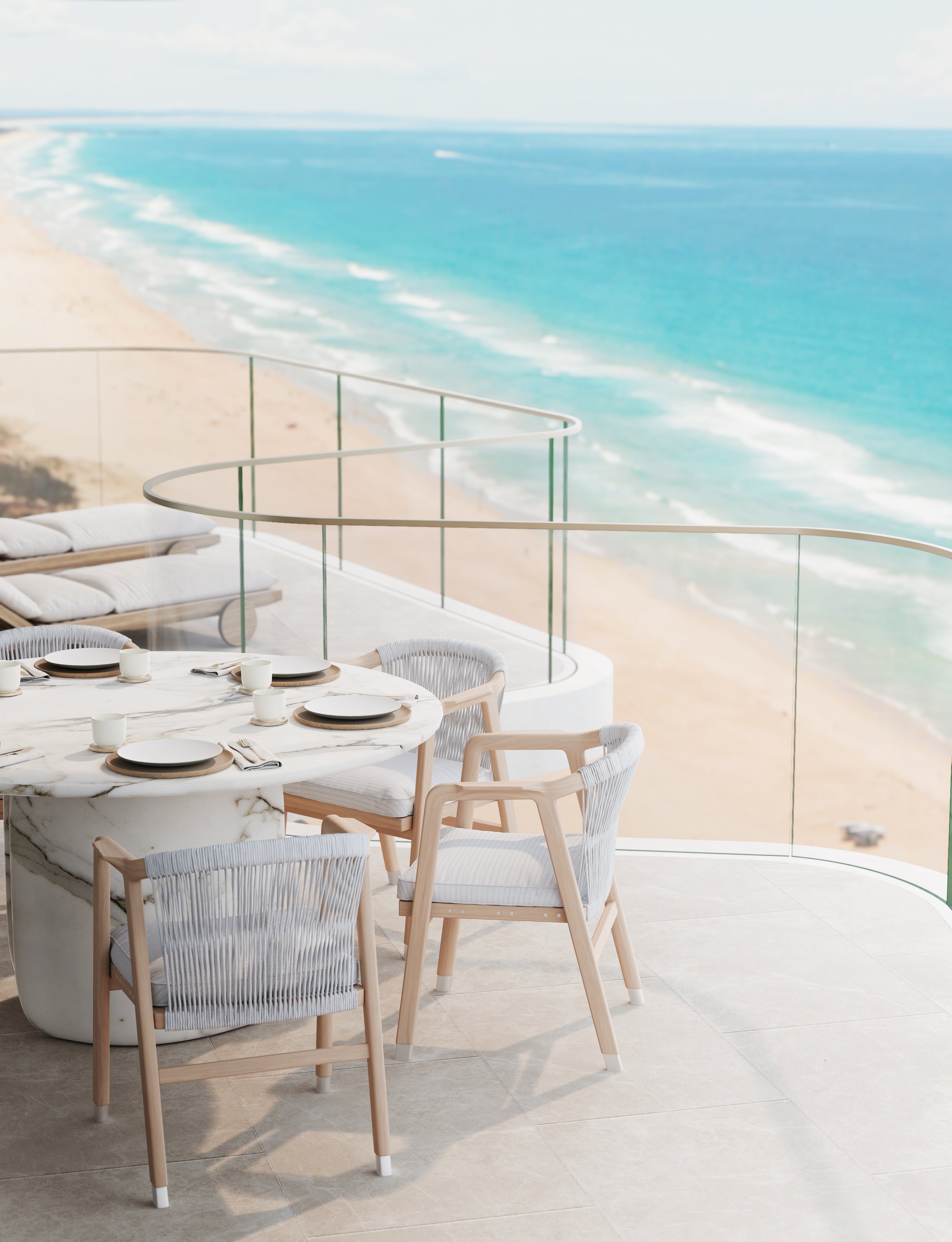 Elegant outdoor dining setup on a balcony with a view of a sandy beach and blue ocean.