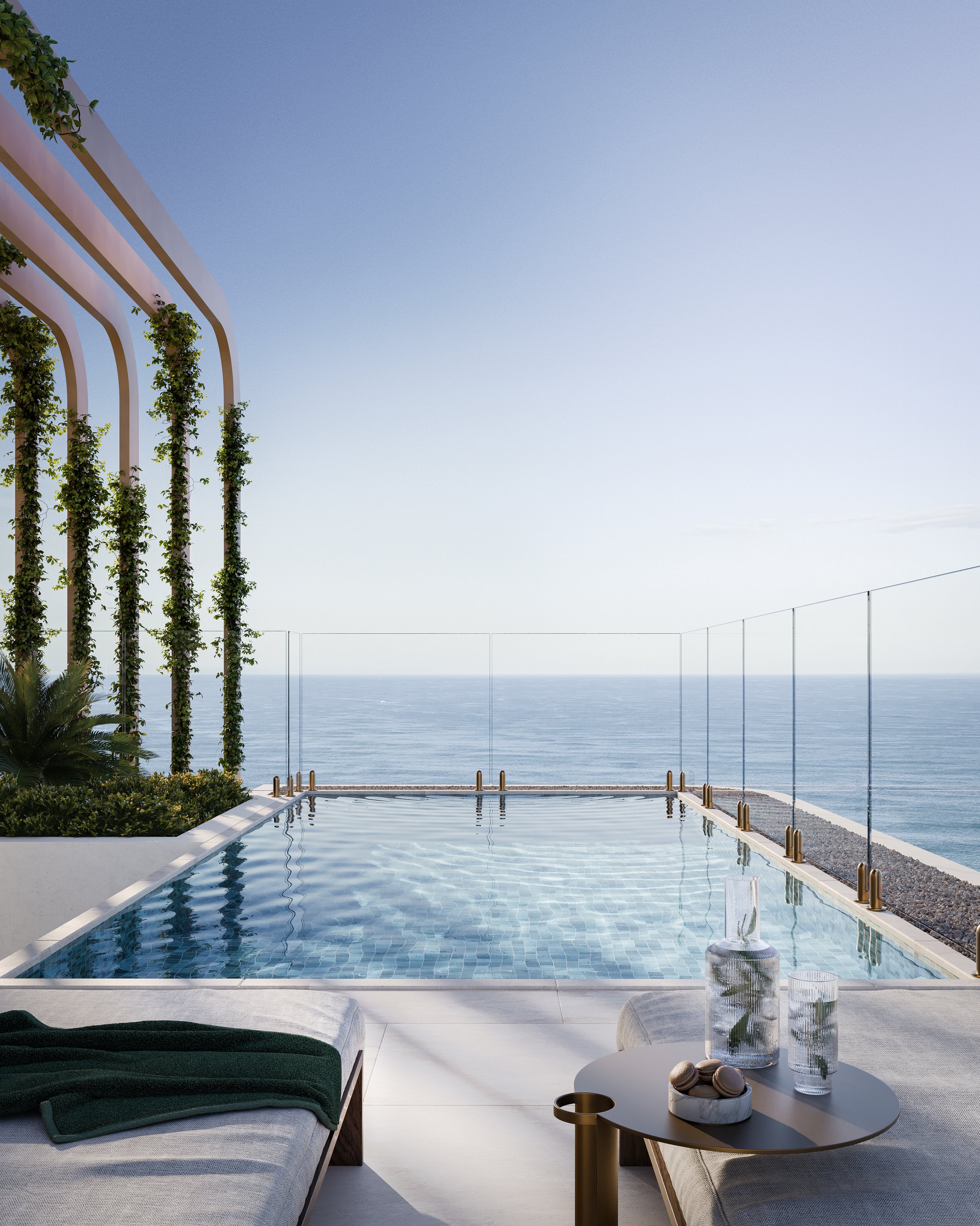 Modern rooftop pool with ocean view, glass railings, sun loungers, and a small table with drinks.