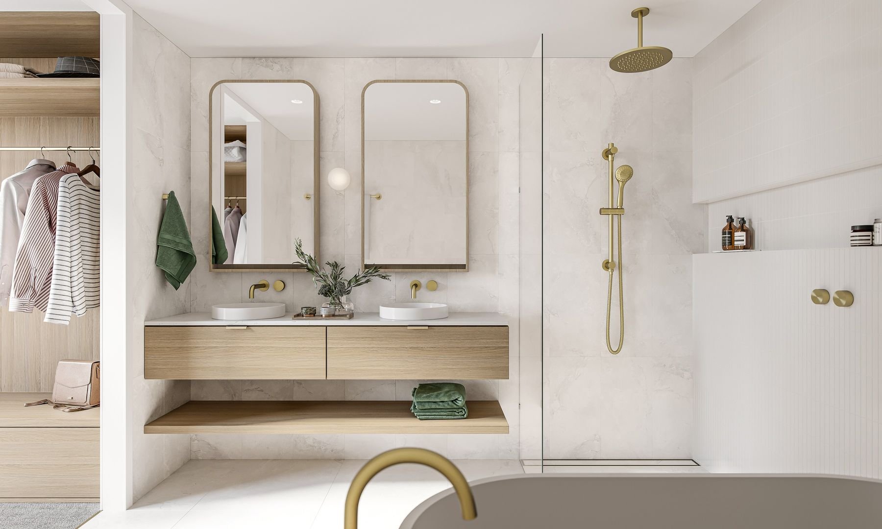 Modern bathroom with double sinks, wooden vanity, large mirrors, gold fixtures, glass shower enclosure, and open closet with clothes.