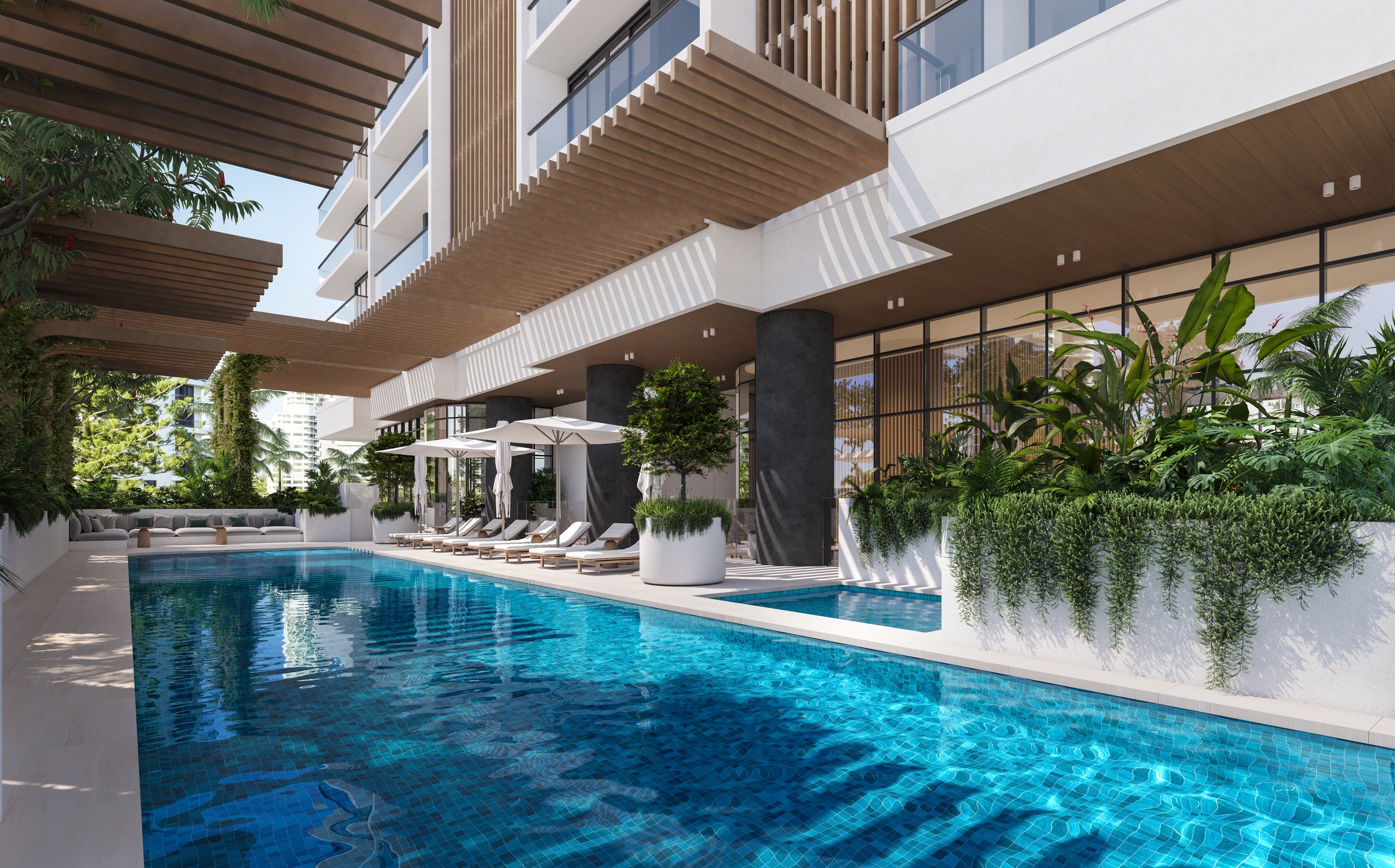 Outdoor pool area with sun loungers, umbrellas, and surrounding greenery at a modern building.