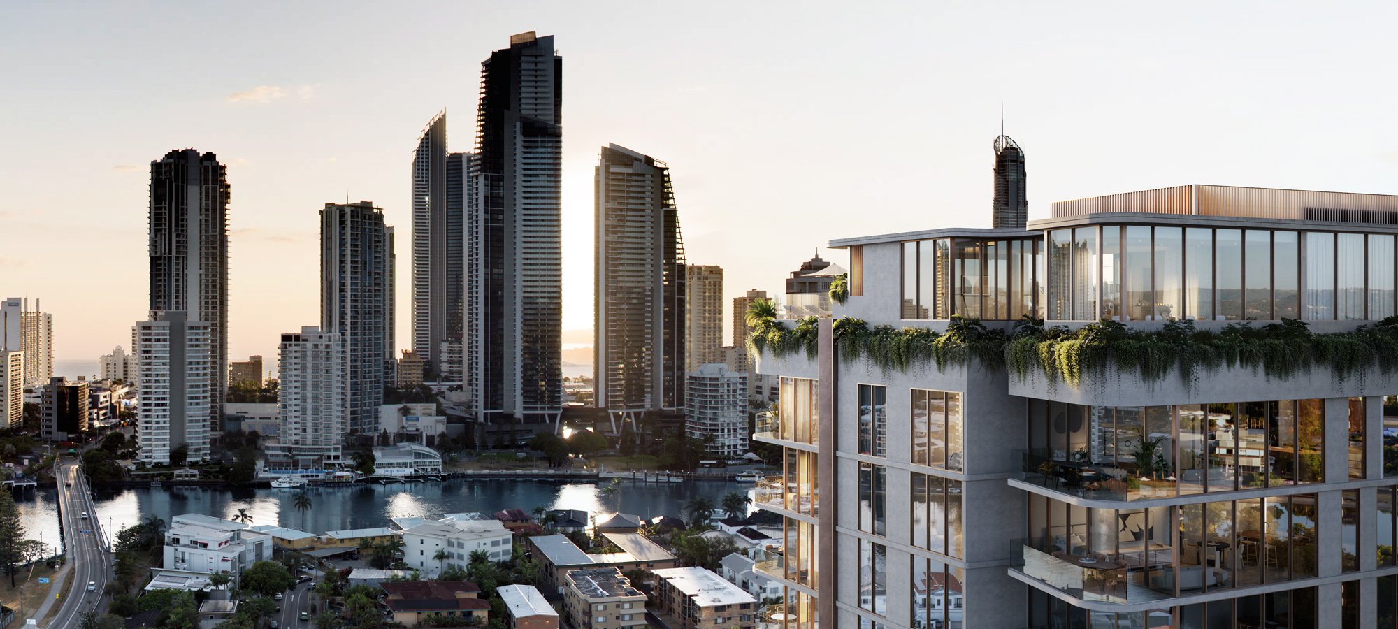 Skyline view of a modern city with tall skyscrapers, a river, and residential buildings; foreground shows a contemporary building with glass windows and greenery.
