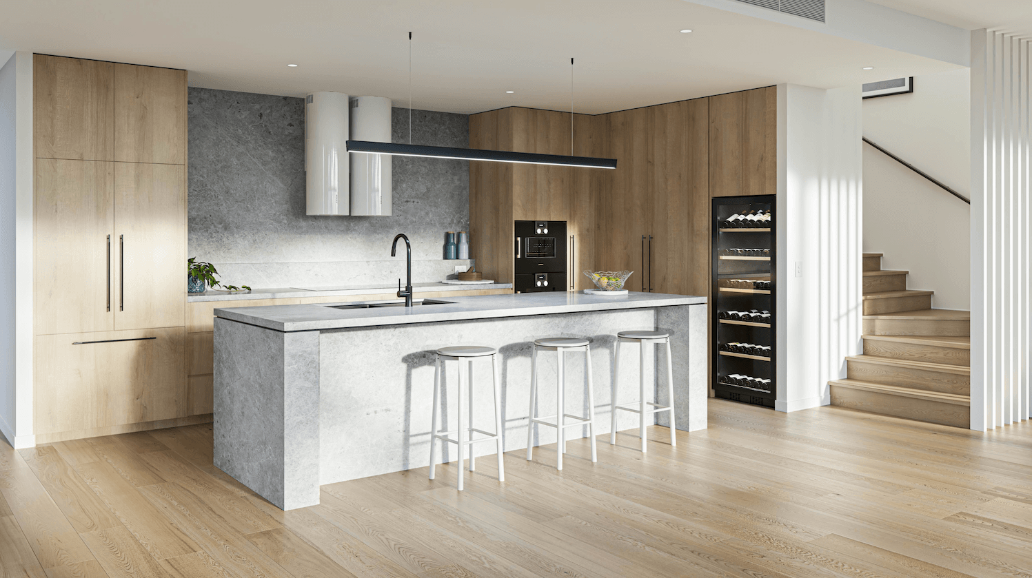 Modern kitchen with wooden cabinets, large island, bar stools, wine cooler, and staircase.
