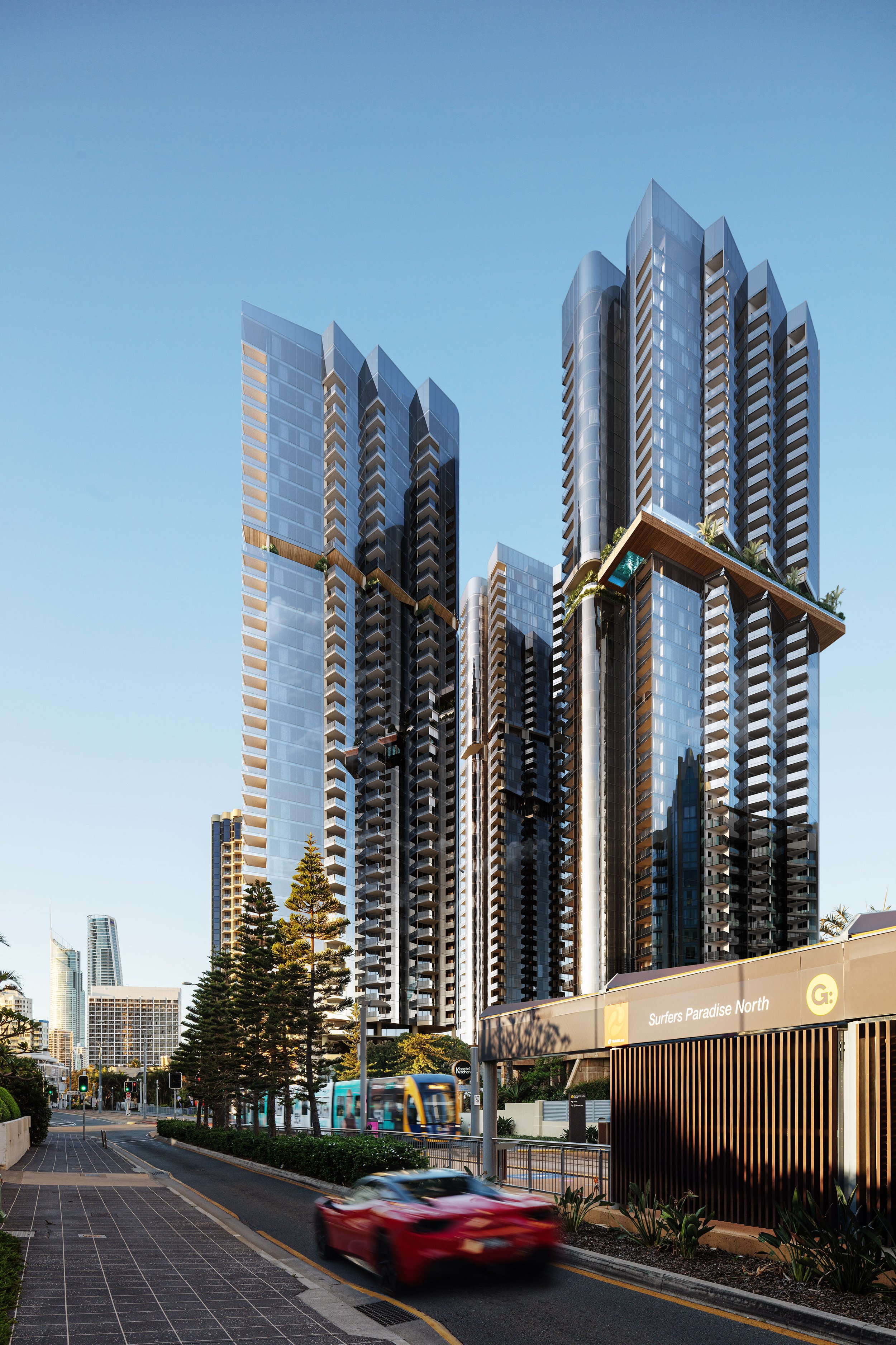 Modern skyscrapers with glass facades in an urban area, featuring a red sports car driving on the road and a tram near the "Surfers Paradise North" stop.
