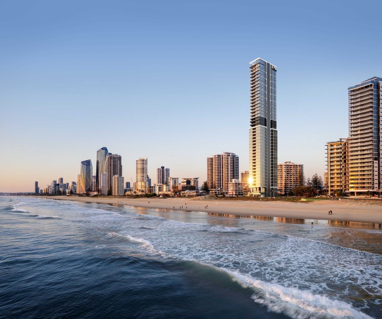 Skyscrapers and beach shoreline in a coastal city at dusk.
