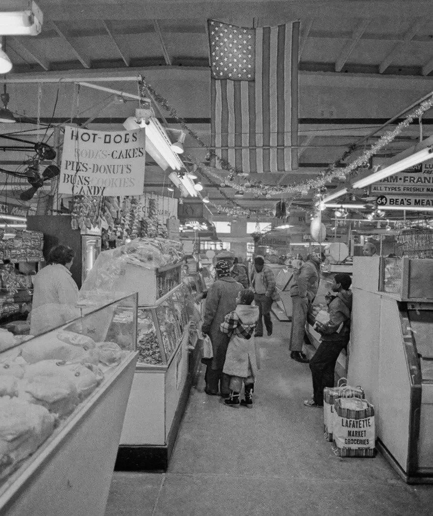 1970s Interior view of Lafayette vendors with their stalls decorated for the holidays.