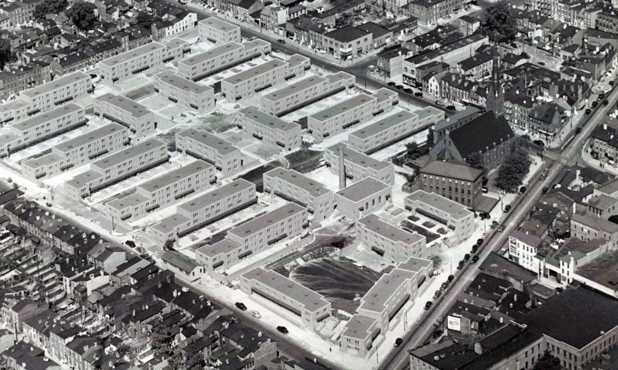 1940
Beginning in the 1930s, the City’s “slum clearance” efforts sought to reimagine Poppleton. Poe Homes (shown here during construction) opened as the first public, but segregated, housing complex in Baltimore.