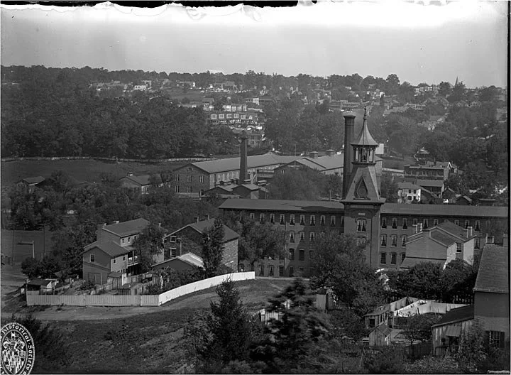circa 1890
3851 Falls Road was originally built to support the growing number of workers for Meadow Mills (foreground). Falls Road can be seen at the top of the hill. (Maryland Center for History & Culture)