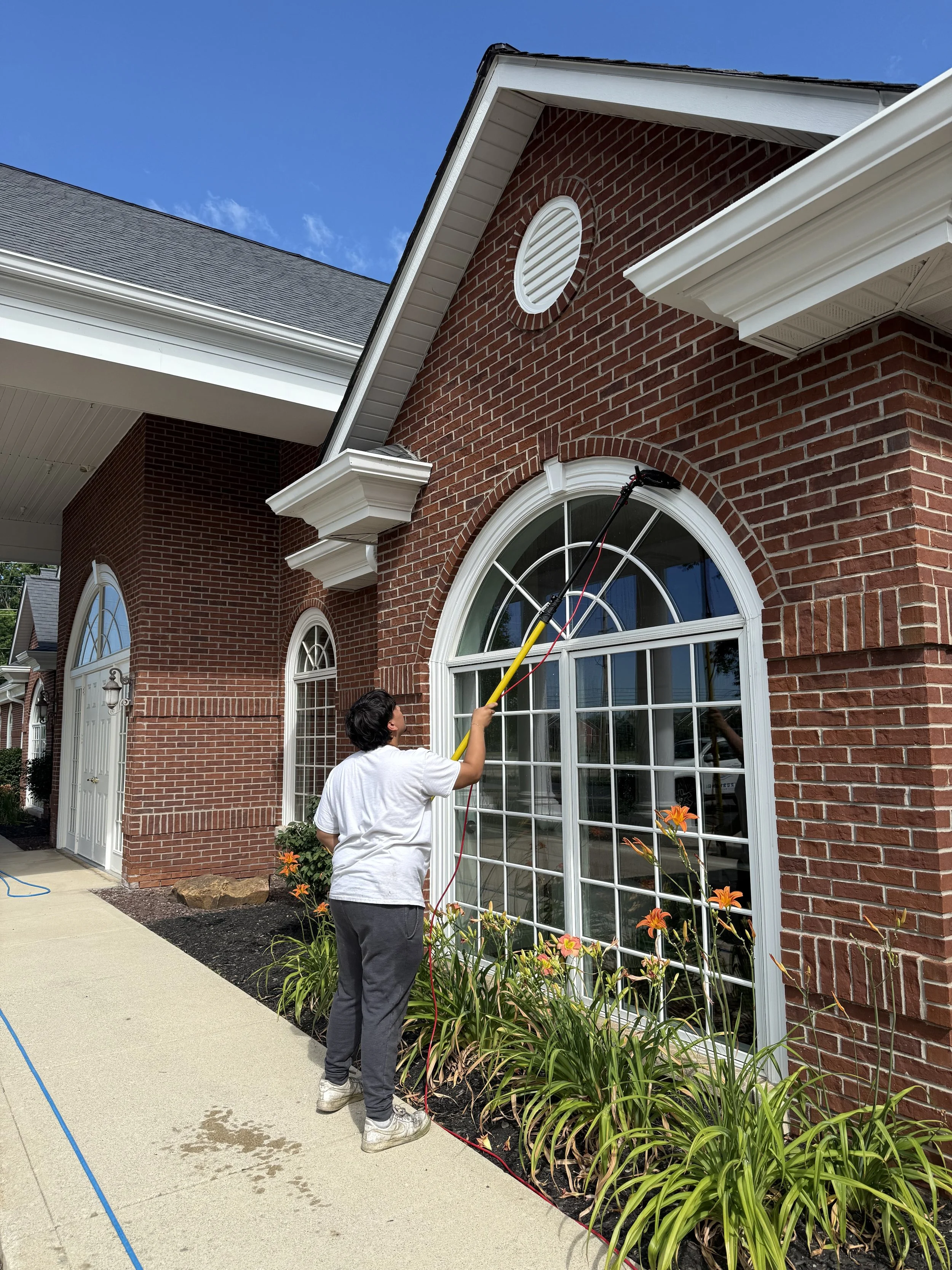 Commercial brick building window cleaning using extendable water-fed pole