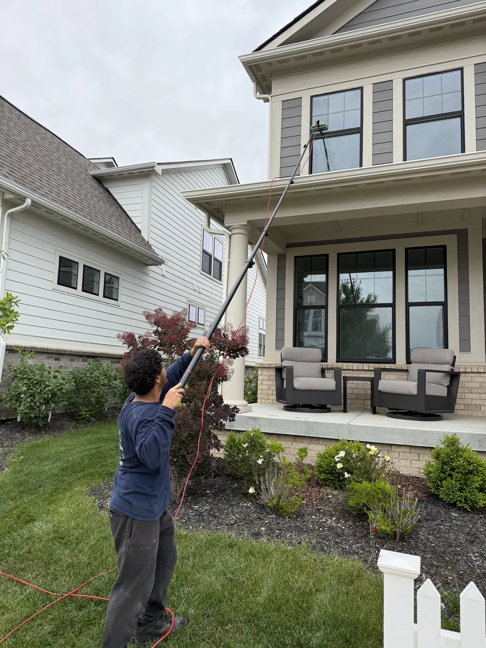PureShine crew member cleaning windows with a water-fed pole
