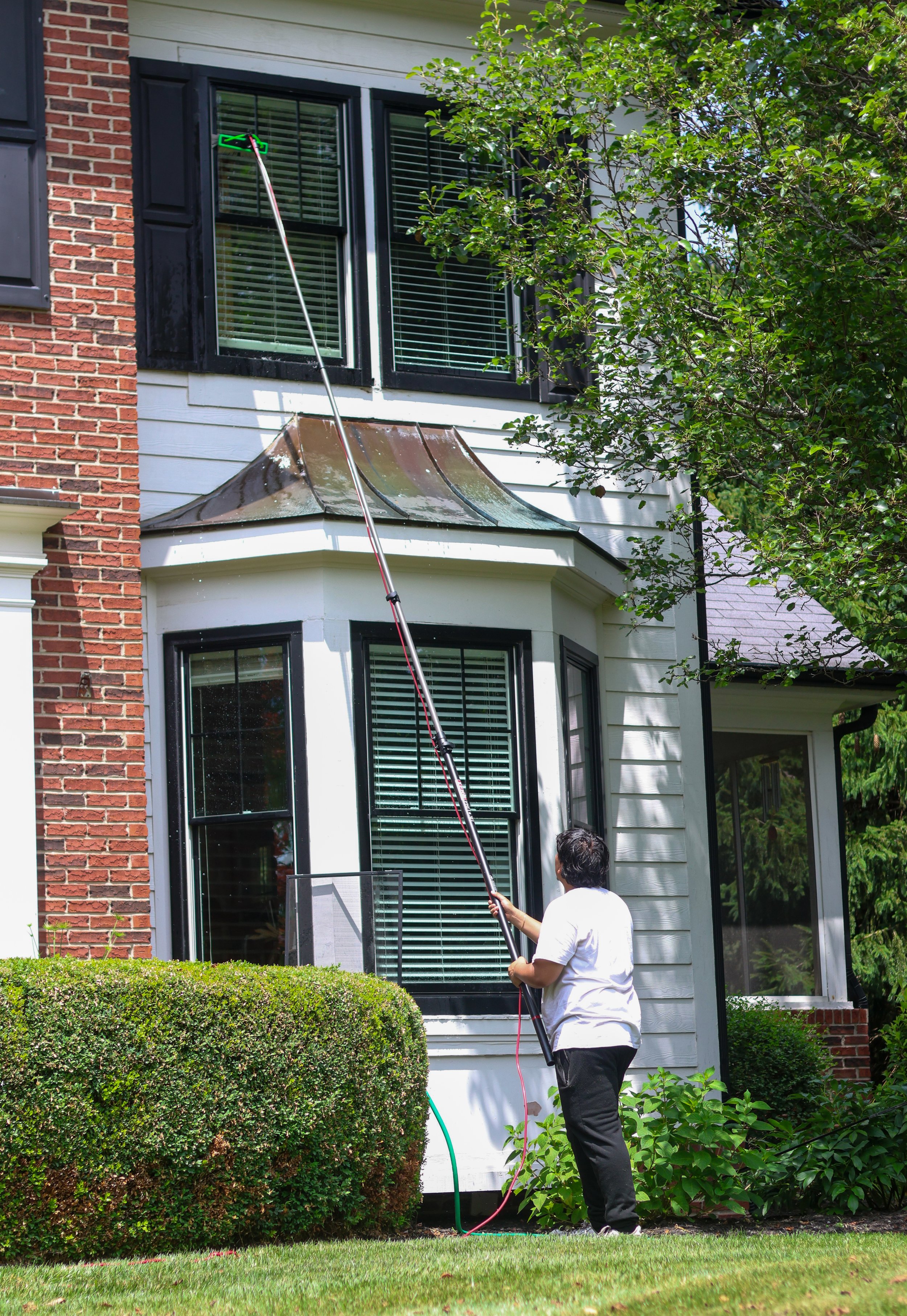 Professional residential window cleaning on second-story windows with water-fed pole in Carmel Indiana
