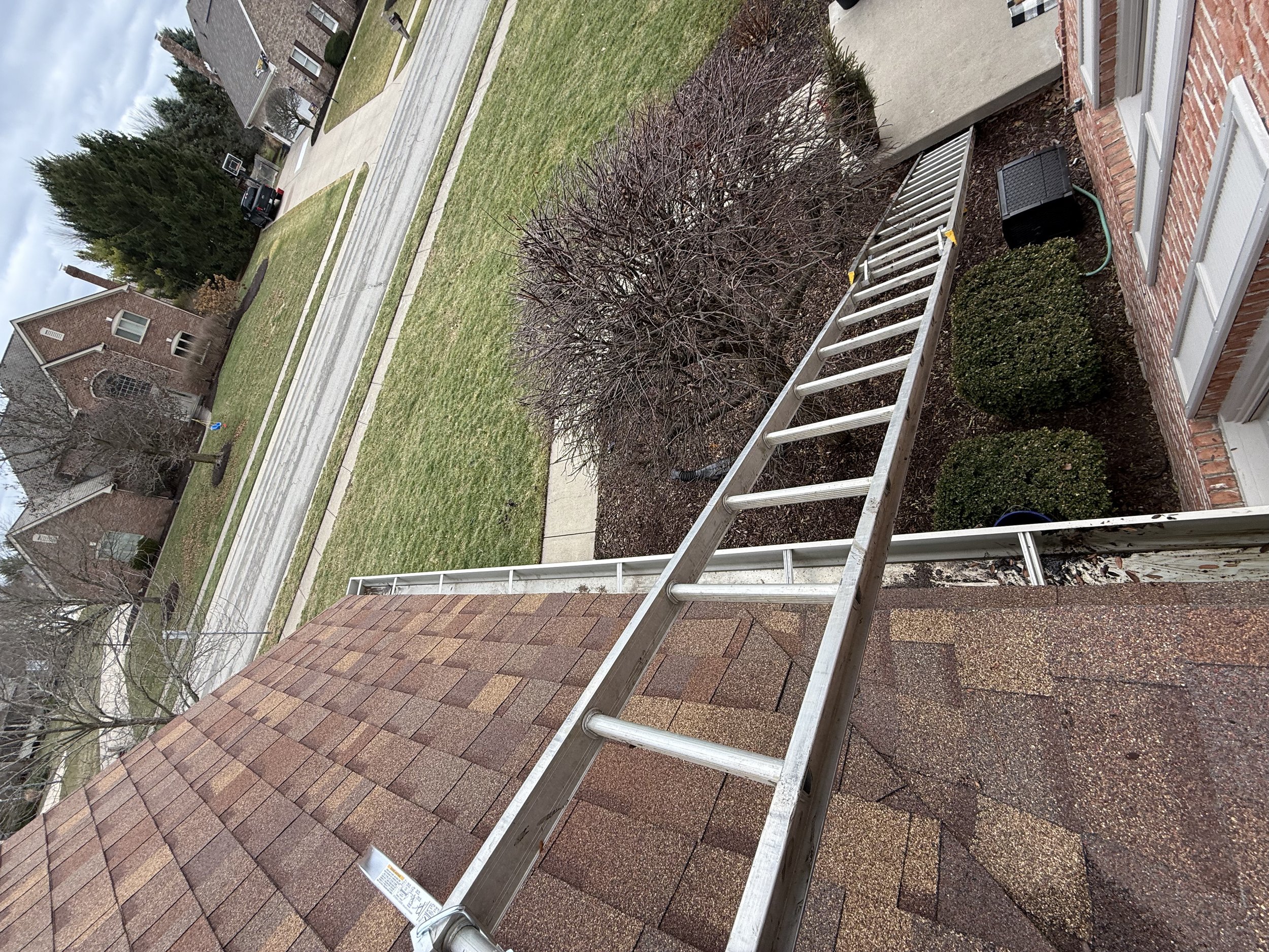 Professional gutter cleaning on residential home in Carmel Indiana removing leaves and debris