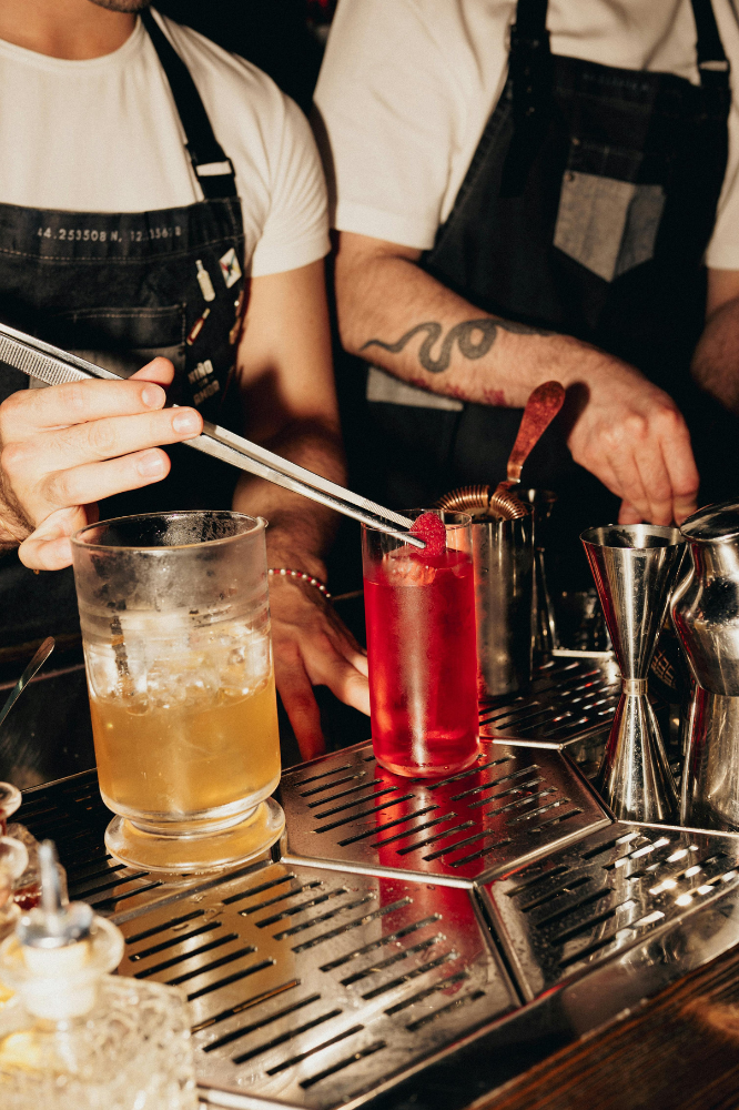 two bartenders mixing cocktails