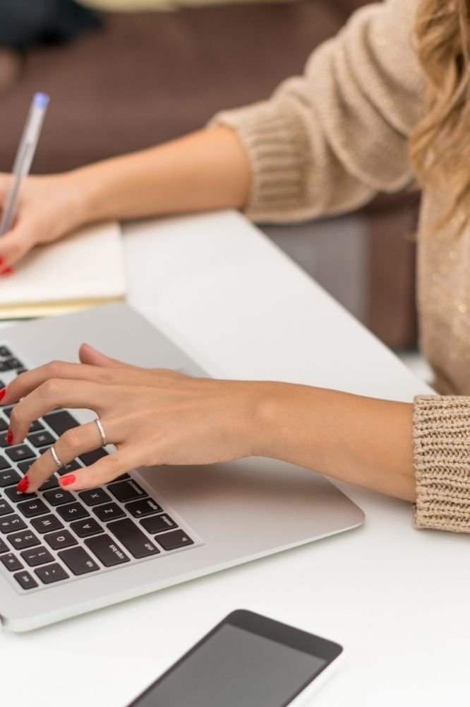 woman taking notes and typing