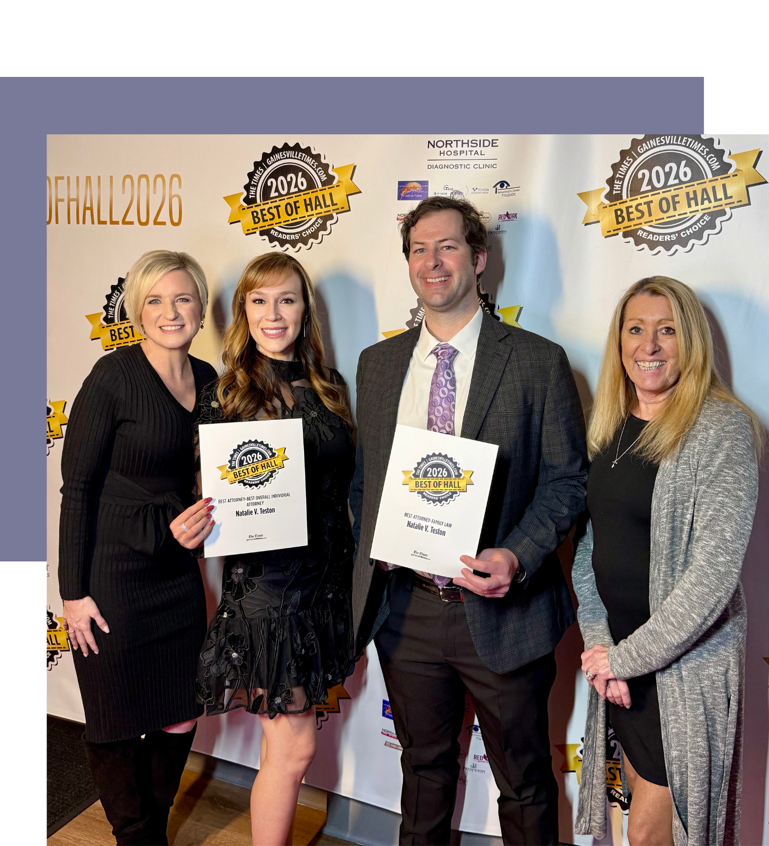 Group of four people at an award ceremony, holding certificates, in front of a backdrop with logos and text celebrating the 2026 Best of Hall awards, with two of them smiling at the camera.