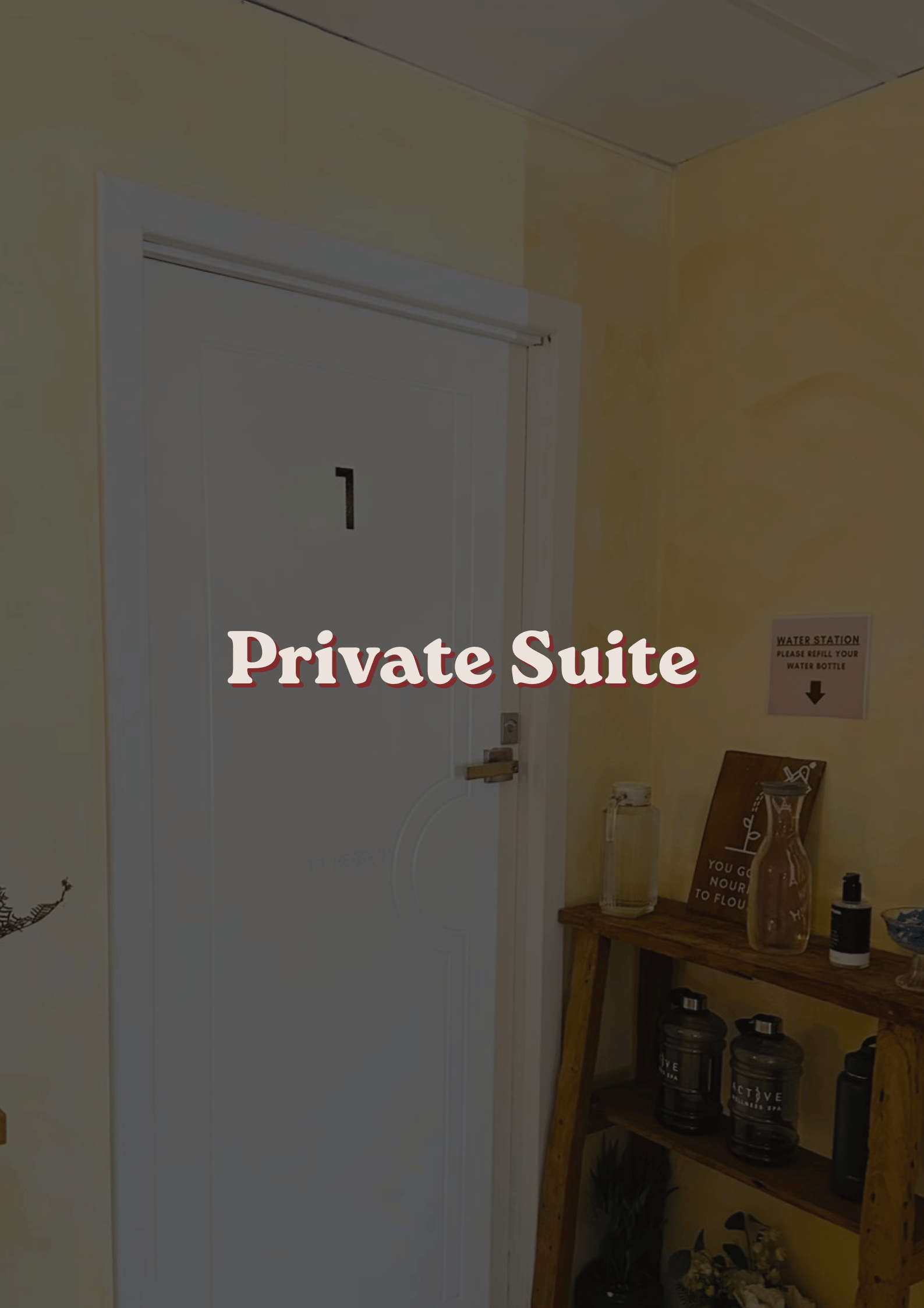 Door labeled 'Private Suite' in a room with yellow walls, next to a wooden shelf holding water bottles, decorative signs, and plants.