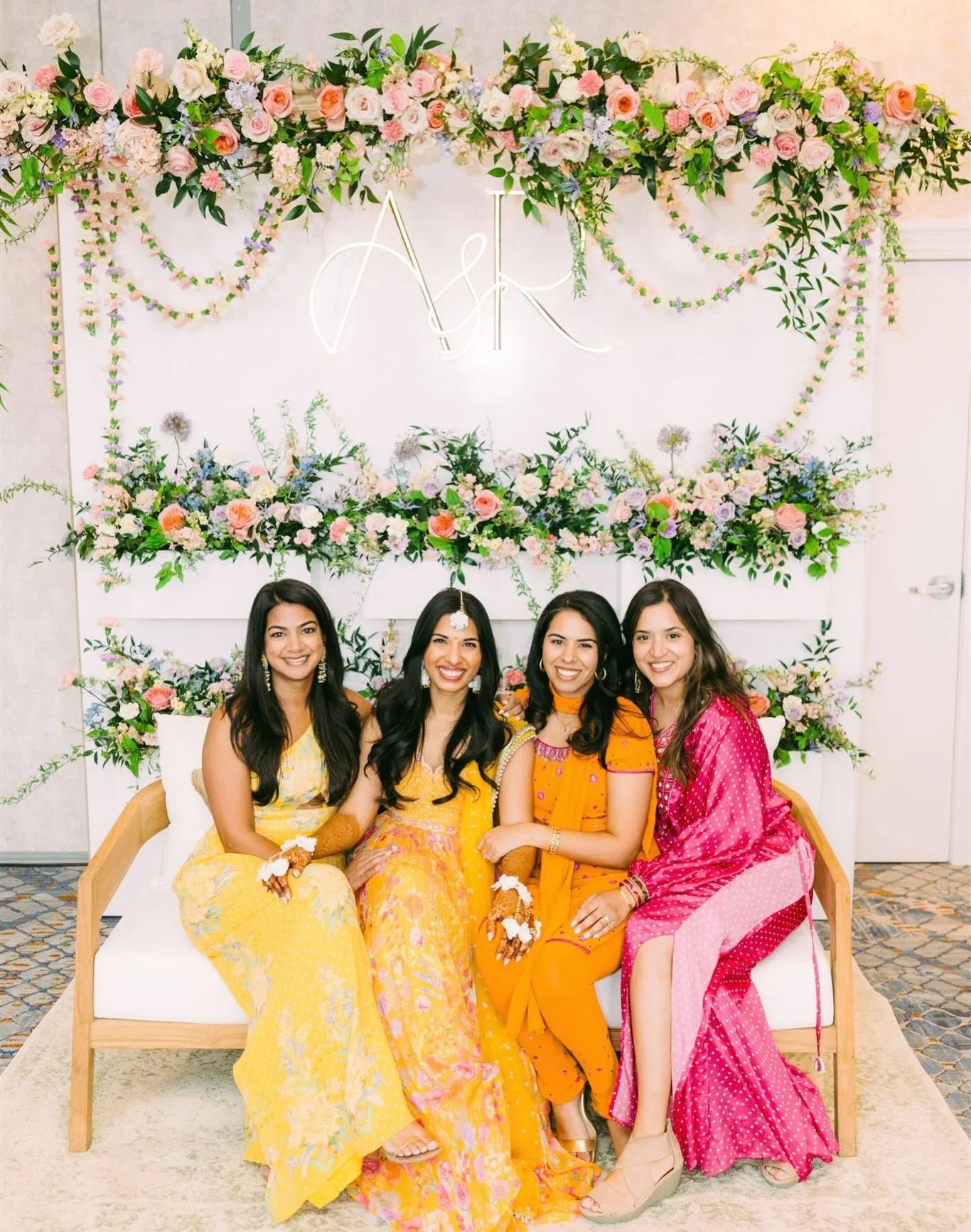 Spring flowers enhancing each moment of this three day-Indian wedding celebration : we love the floral garlands strung at the top of this Haldi backdrop, the lush blooms and vibrant, joyful attires - coming together to create an unforgettable weekend