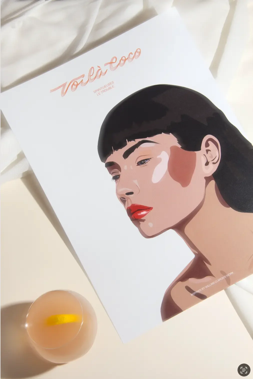 Illustration éditoriale d'une femme brune troublée avec rouge à lèvres rouge, décor blanc immaculé avec tissus, cocktail rosé beige dans verre rond, direction artistique rétro.