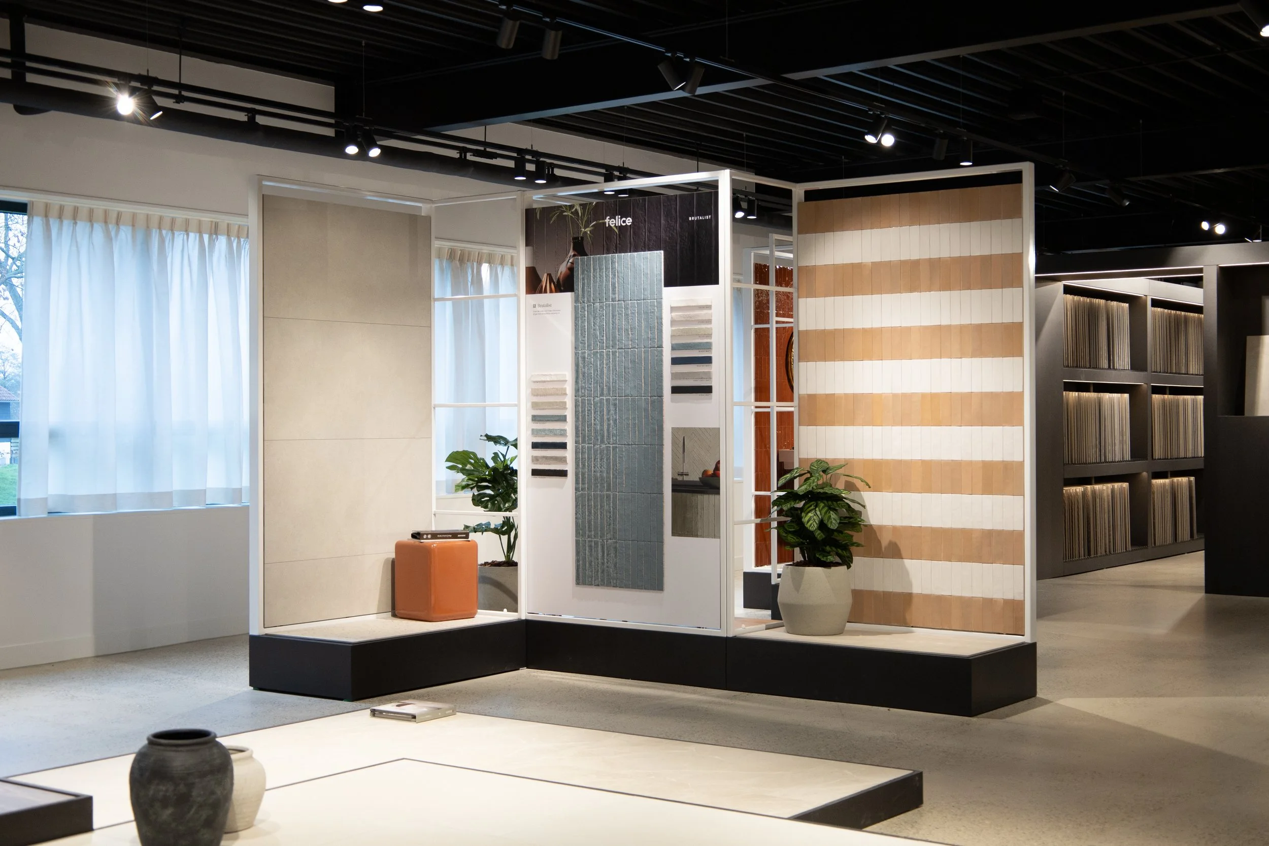 Interieur van een woonwinkel met wandpanelen, vloer- en muurtegels en planten.