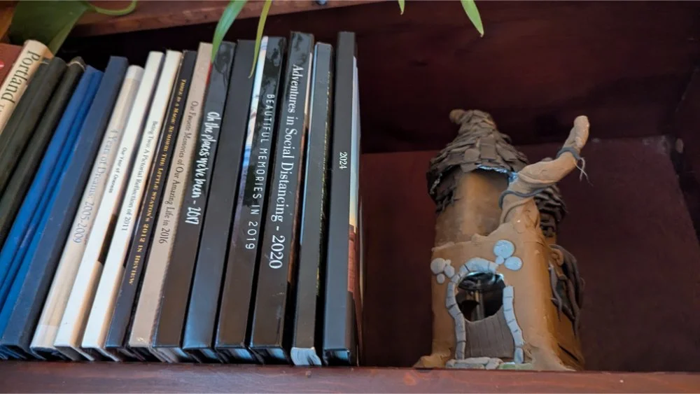 photo books on shelf next to clay castle