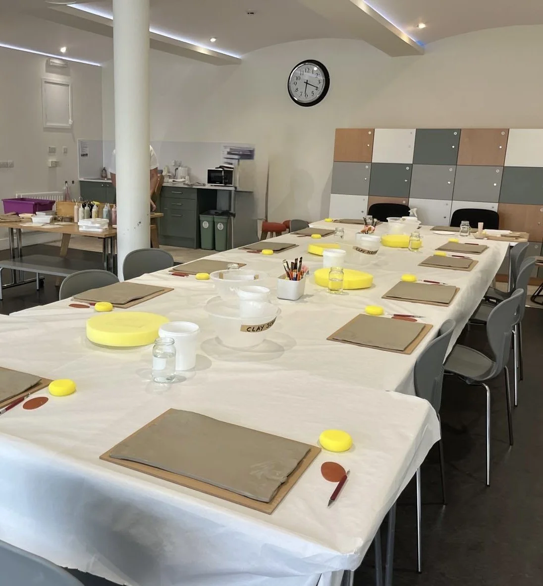 Table set up with tools and wooden boards for pottery workshop.