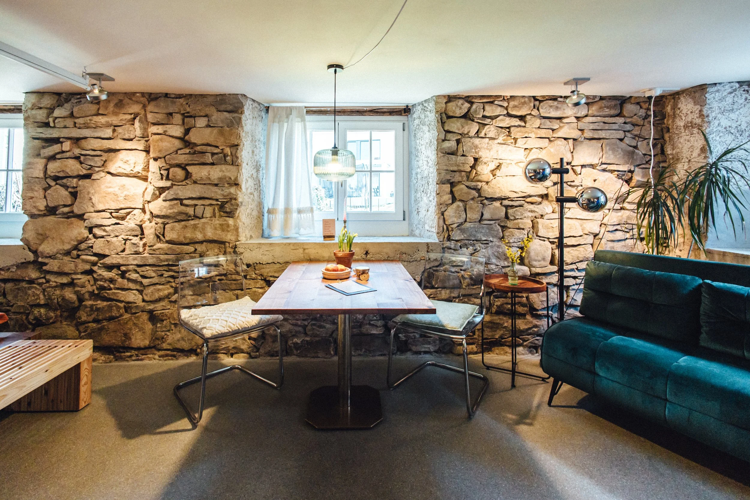 Ferienwohnung rustikal mit Natursteinmauer und modernem Interieur, Essbereich, Schlafsofa und Vintage Stehlampe