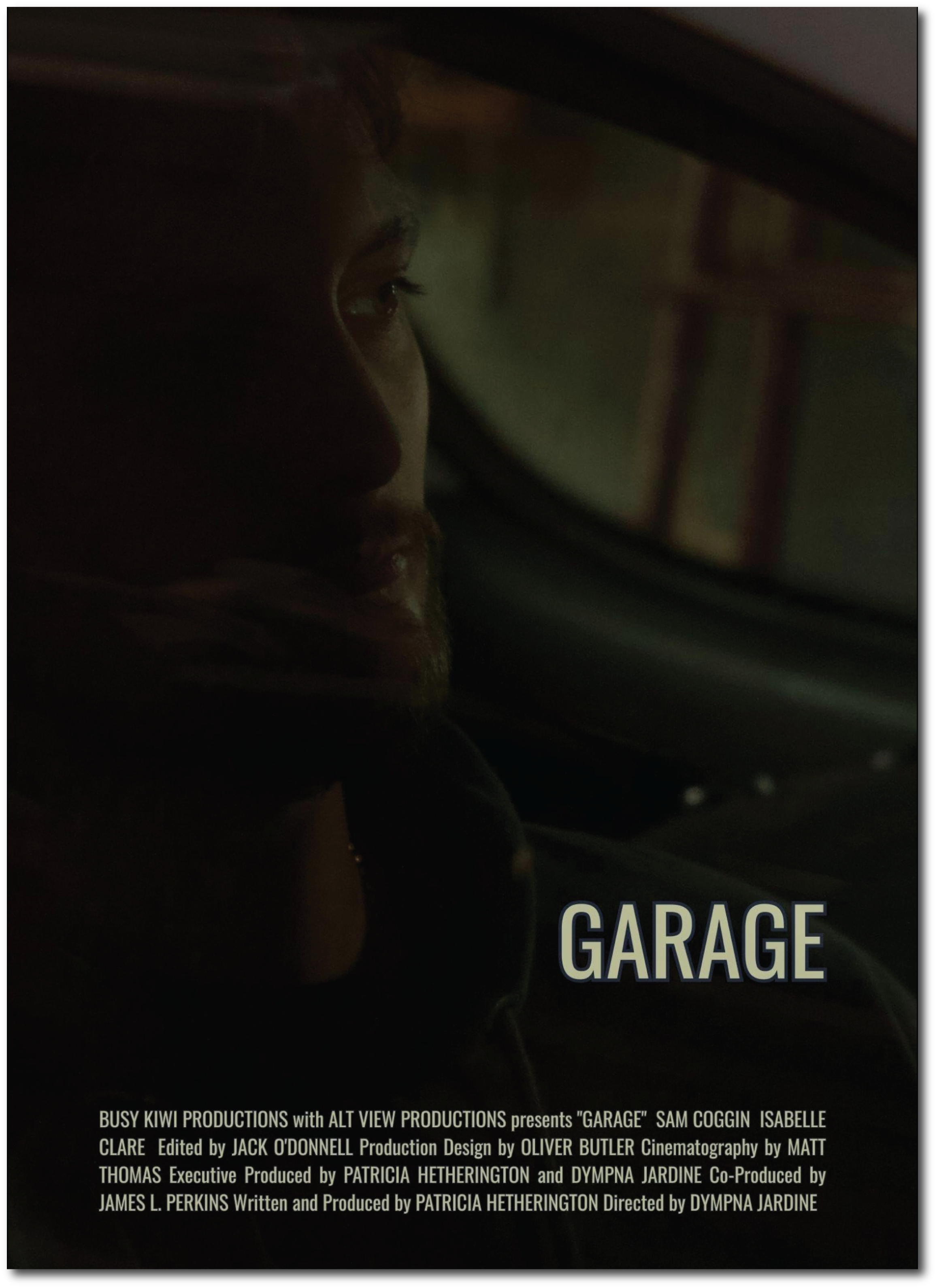 The image is a dark, blurry photo with the word "GARAGE" partially visible at the bottom and some text in smaller font below. The photo appears to be a close-up of a person’s profile in low light conditions, with only the side of their face faintly visible.