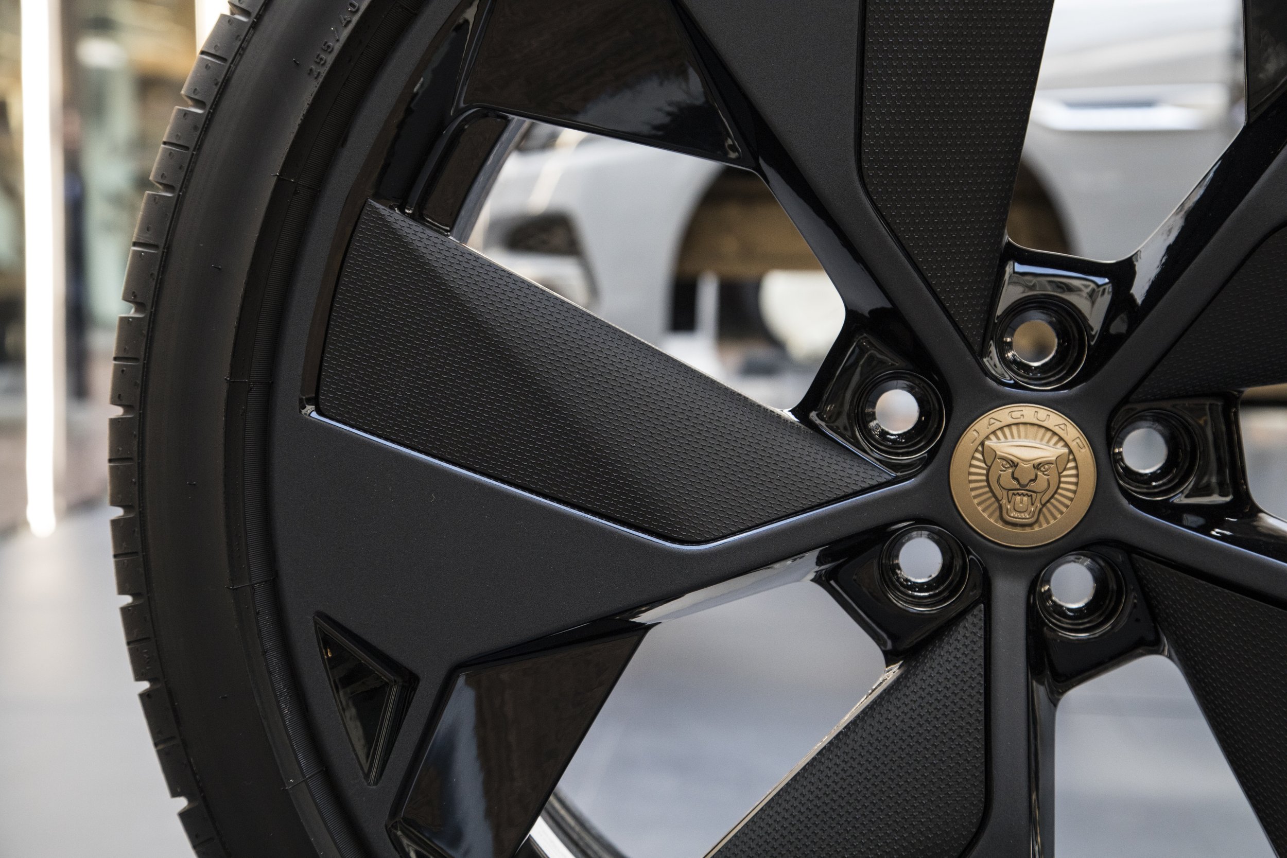 Close-up of a Jaguar car wheel with logo badge.