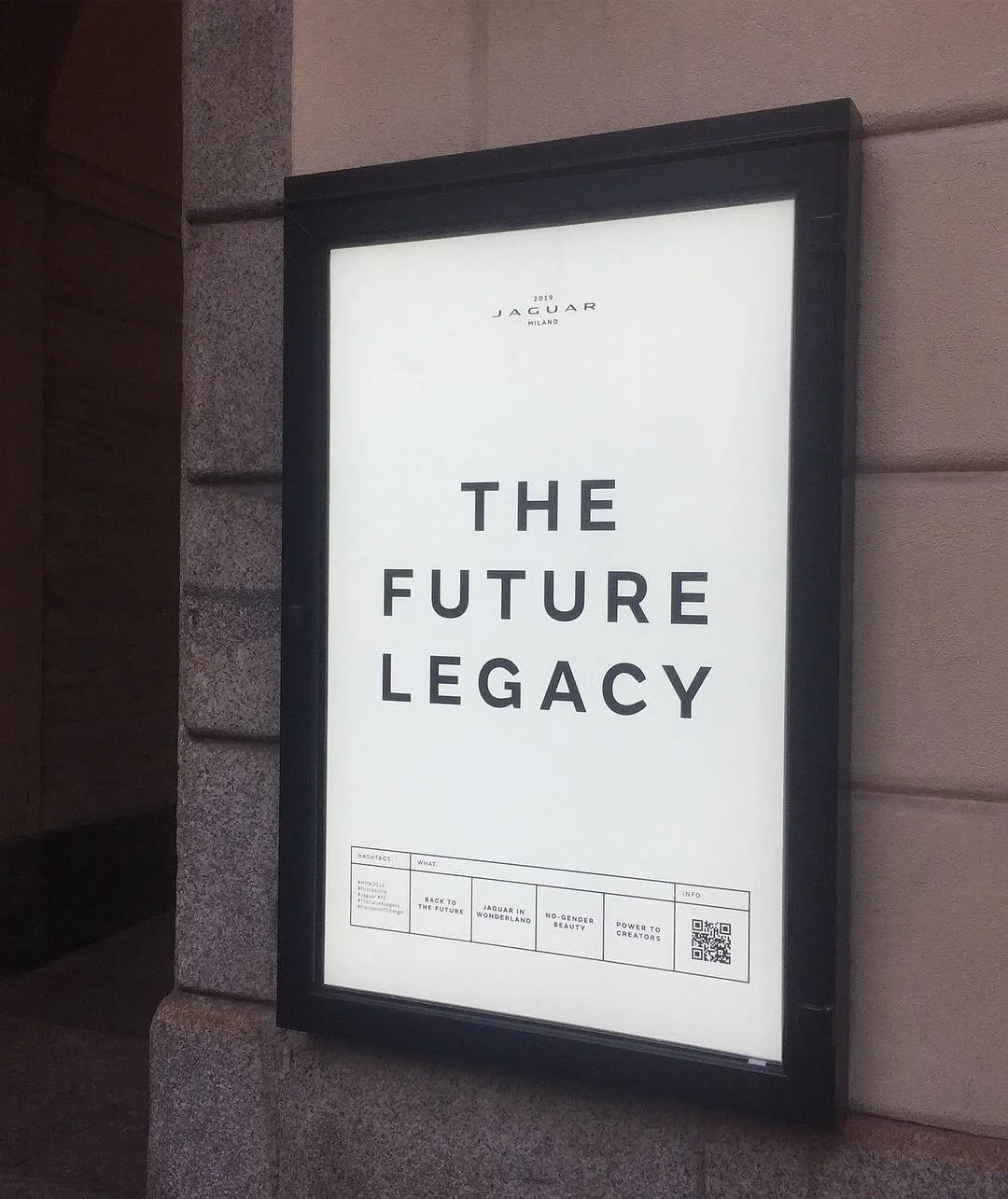 Poster reading 'The Future Legacy' with a Jaguar Milano logo, displayed on an outdoor wall.