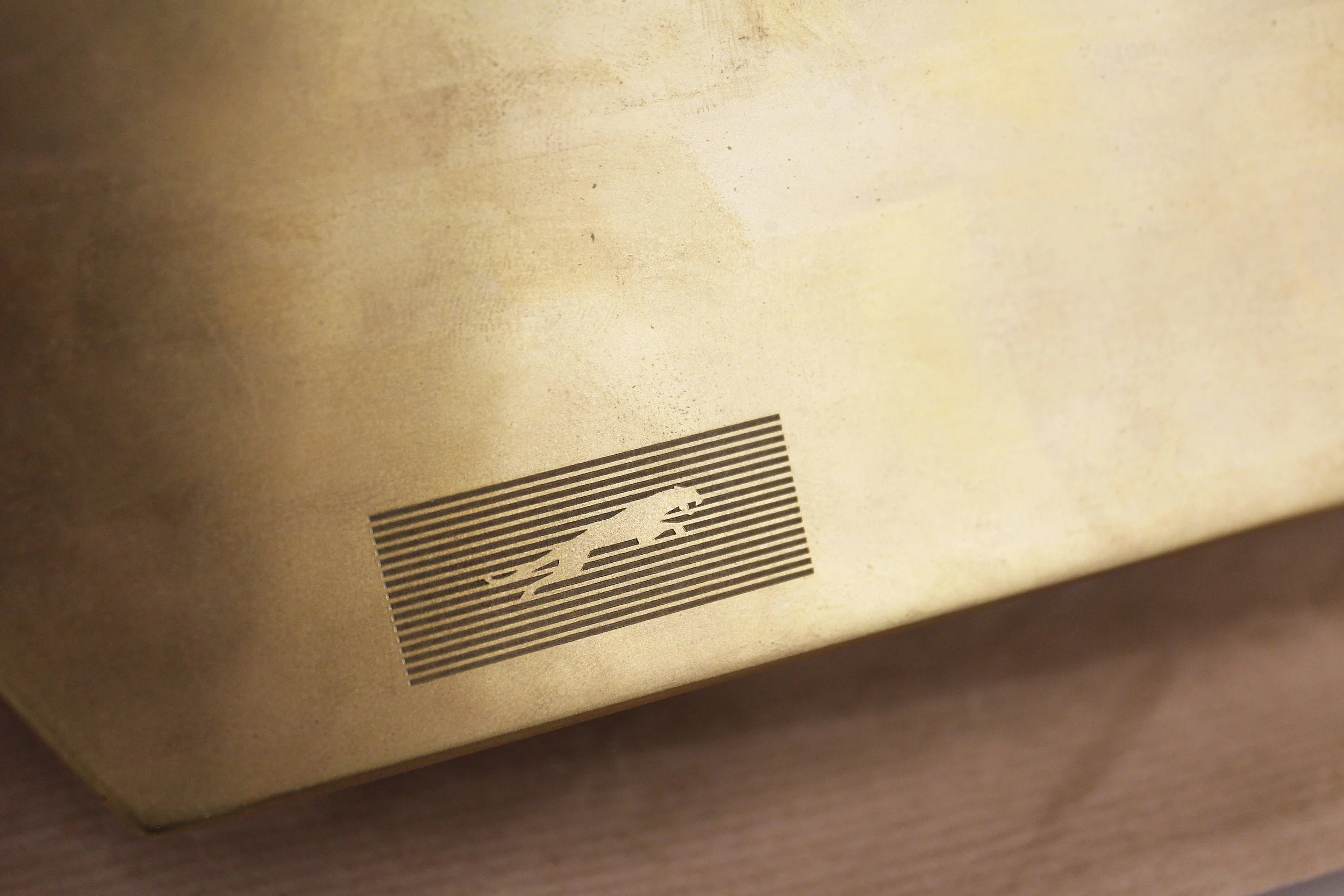 Close-up of a brass object featuring an engraved design.