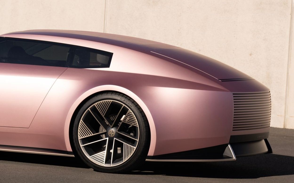 Futuristic pink concept car with sleek design and large rear wheel