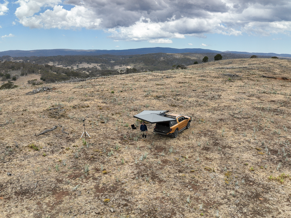 Aerial image of car and drone in field