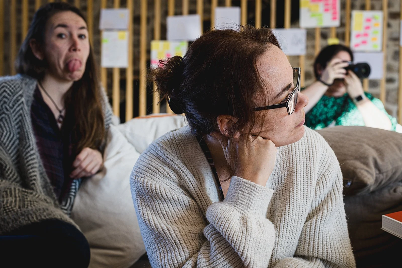 Portrait rapproché d’une femme pensive portant des lunettes et un pull blanc