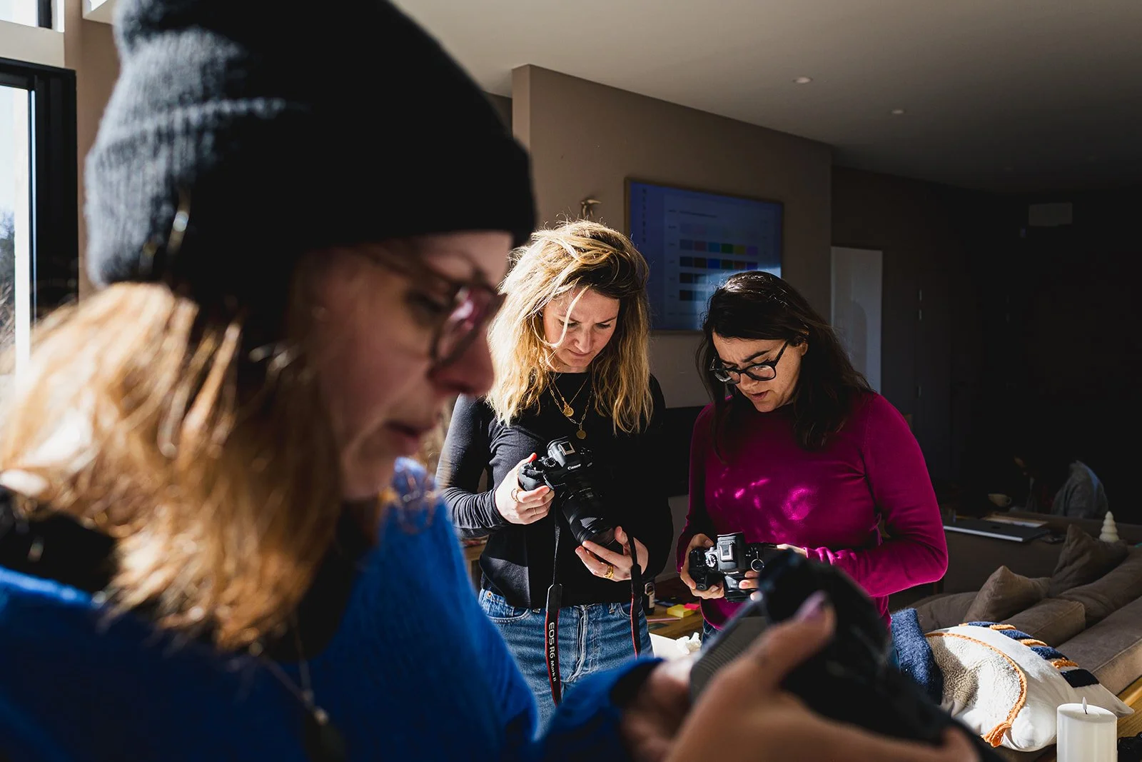 Trois femmes regardant du matériel photo dans un espace intérieur bien éclairé