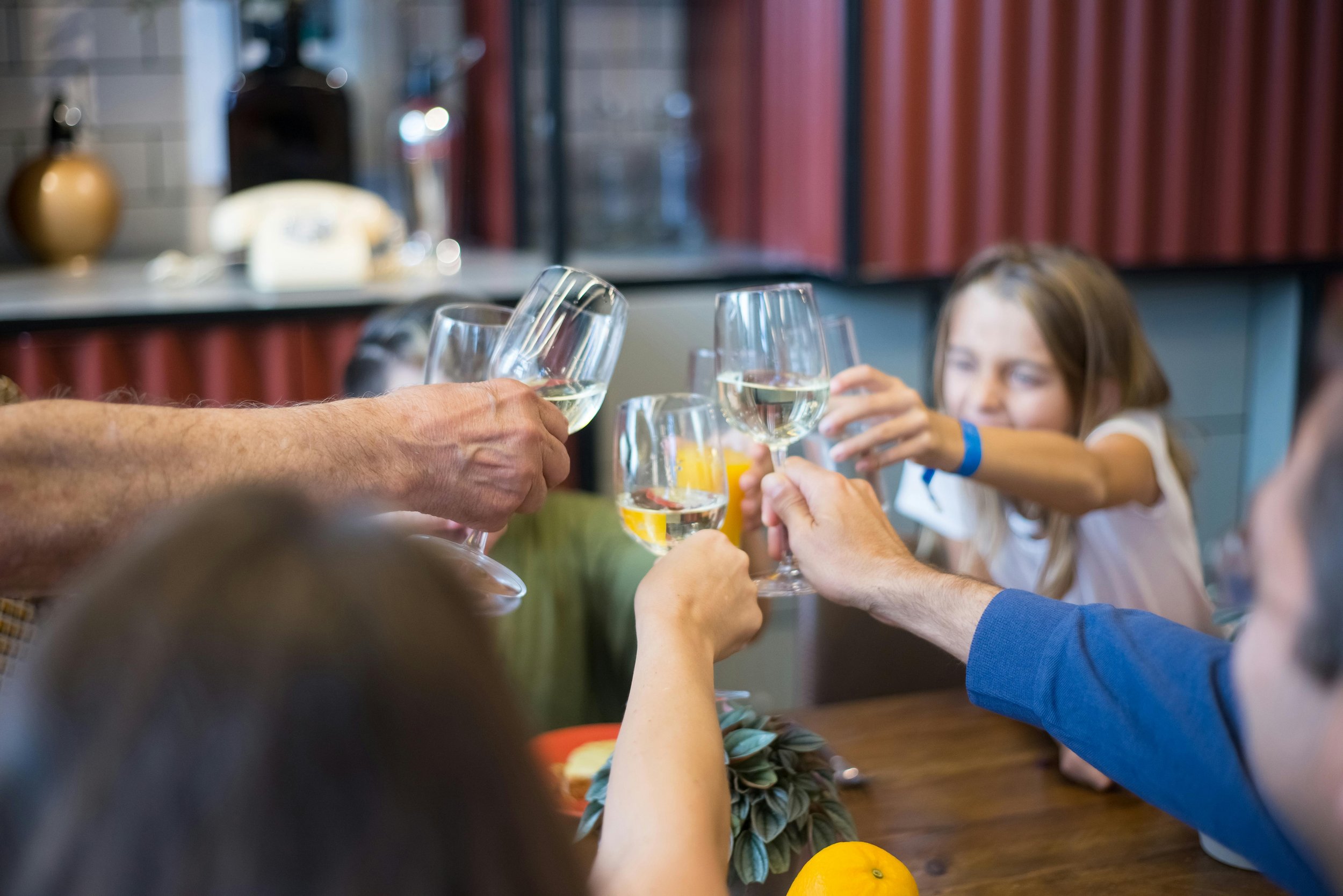 Grupp människor som skålar med glas runt ett bord. På restaurangen The Fairway på Motala Golfklubb.