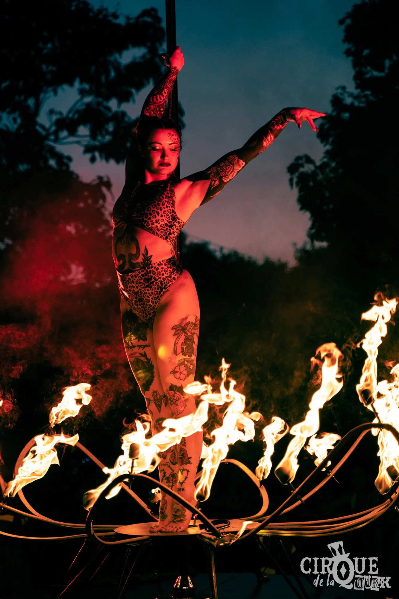 Pole performer Jojo Fox performing fire lotus pole at Cirque de la Quirk, Isle of Wight Festival 2025