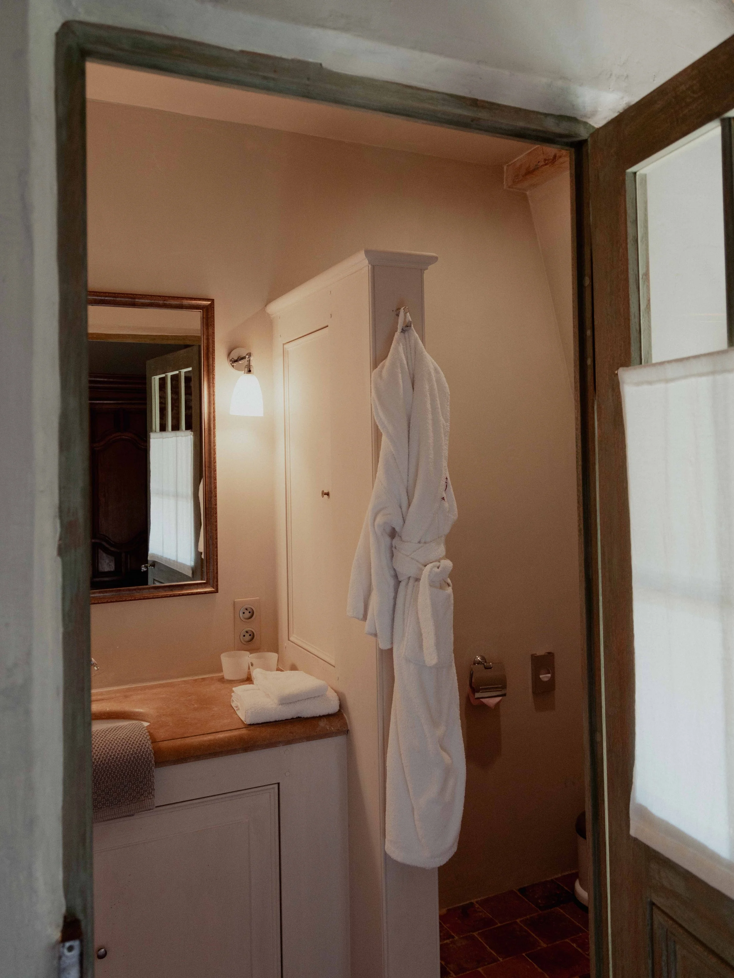 Een badkamer met handdoeken en een spiegel.