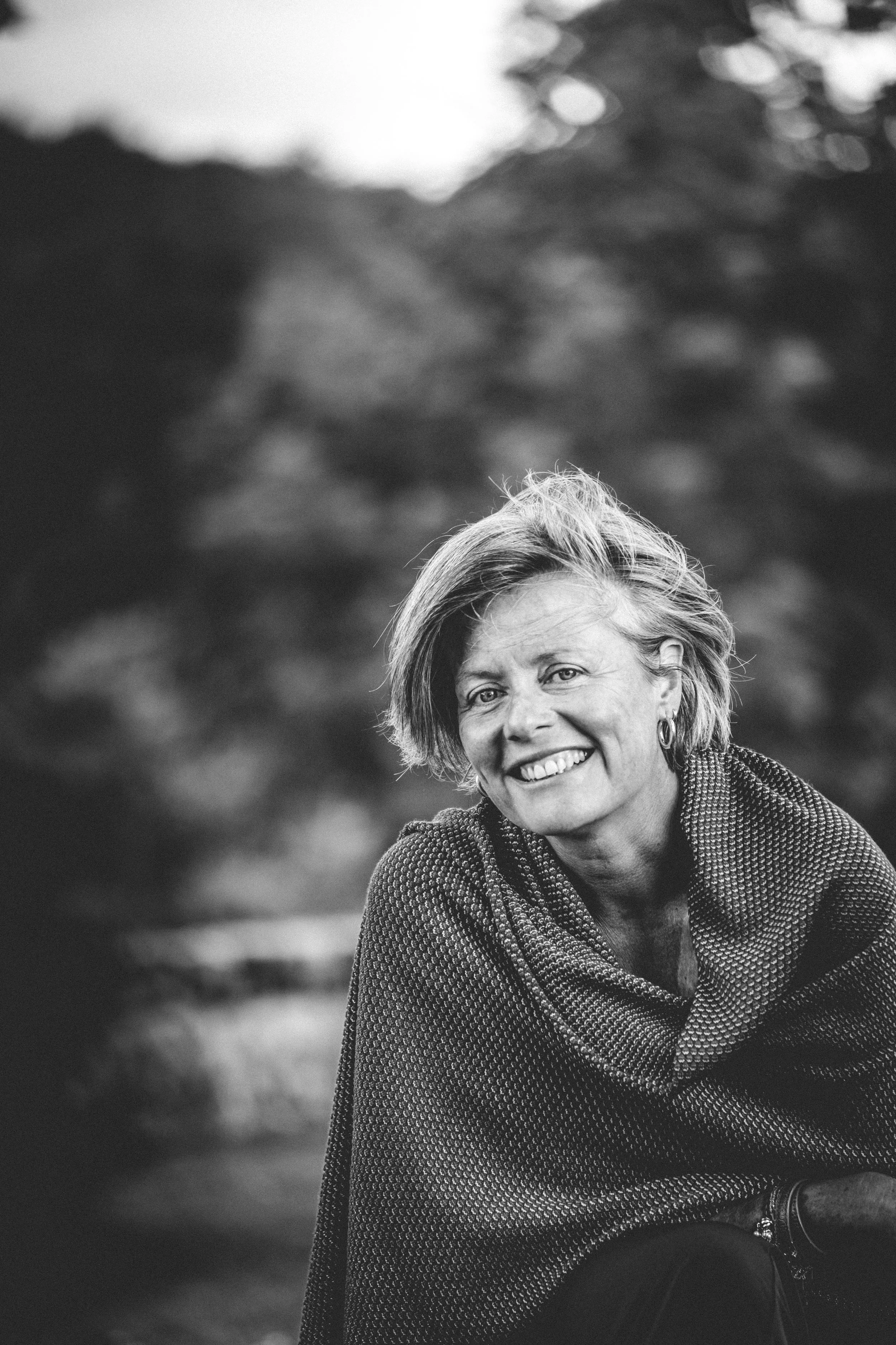 Zwart-wit foto van een glimlachende vrouw met korte haar, eigenares van Laudonie.
